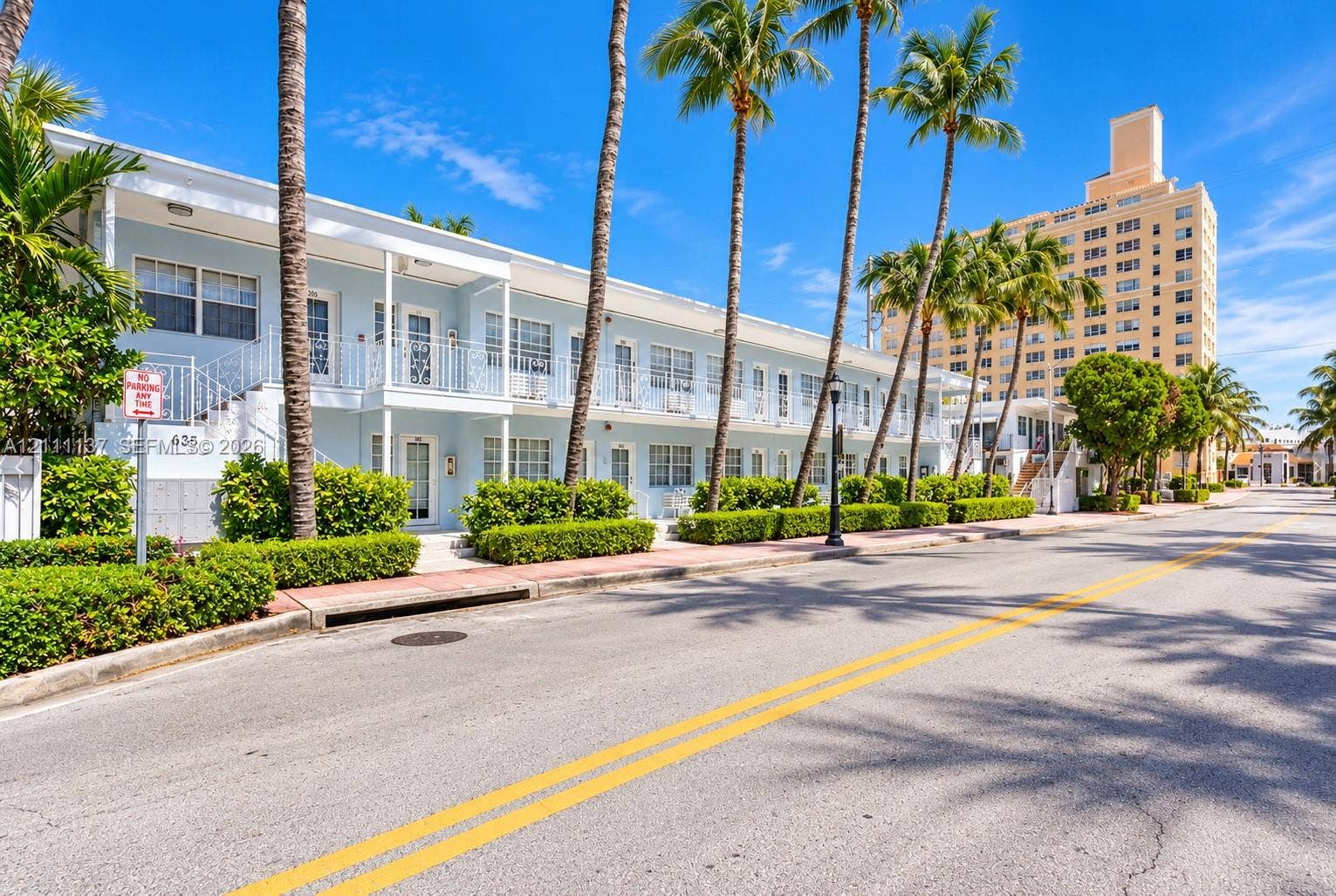 635 8th Street, #205, Miami Beach, Miami Beach, FL 33139 Two-story exterior featuring light-toned masonry, wrought iron railings, private balconies, and manicured perimeter landscaping with palm trees