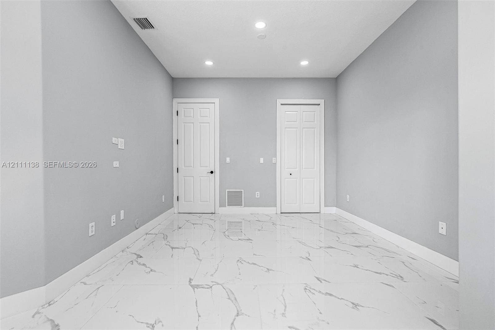 19363 SW 79th Avenue, Cutler Bay, FL 33157 Neutral-toned interior featuring large-format stone-patterned tile flooring, recessed lighting, and white panel doors