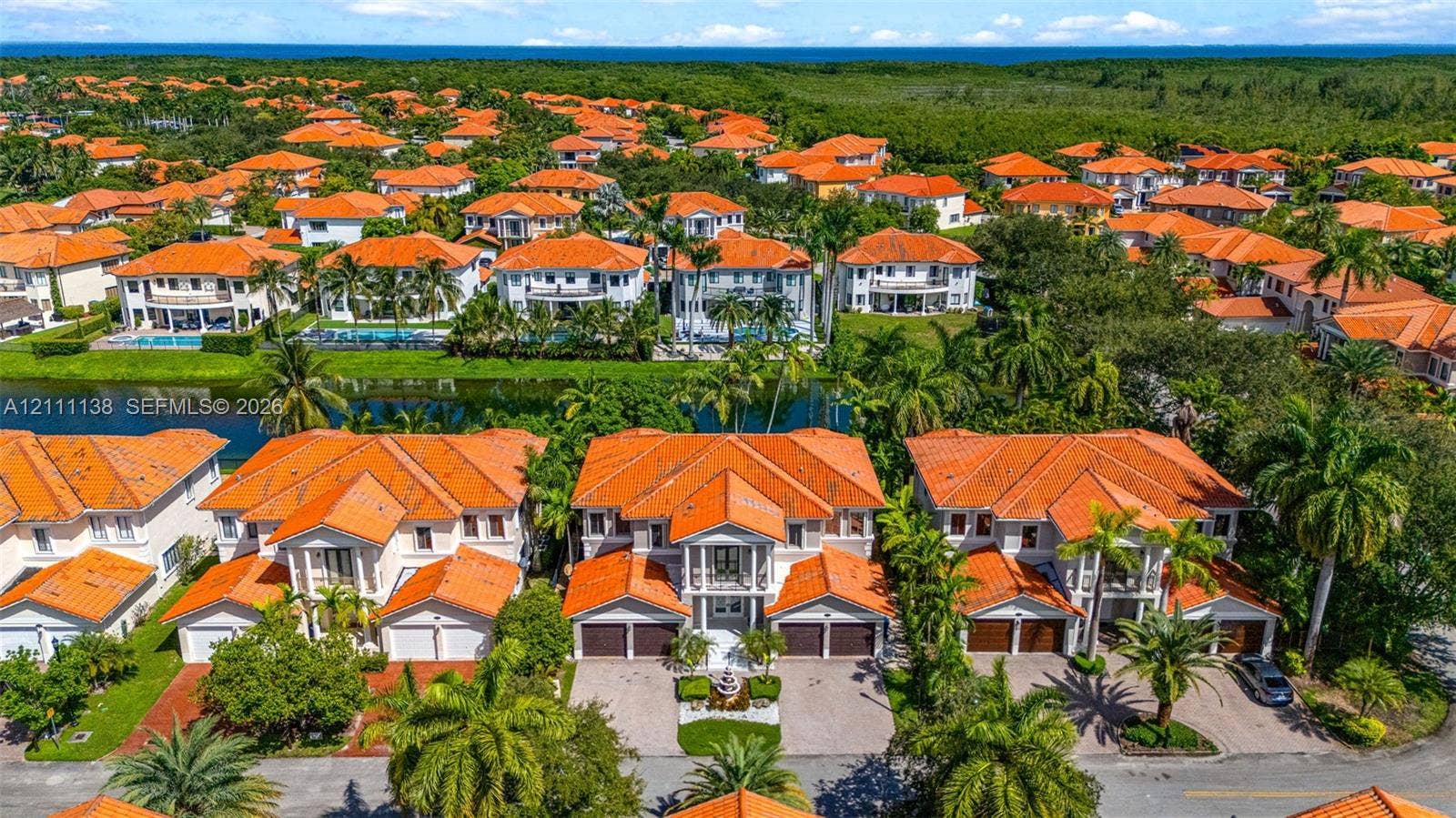 19363 SW 79th Avenue, Cutler Bay, FL 33157 Aerial perspective featuring multi-story residences with terracotta-style tile roofing, paver driveways, and proximity to a canal
