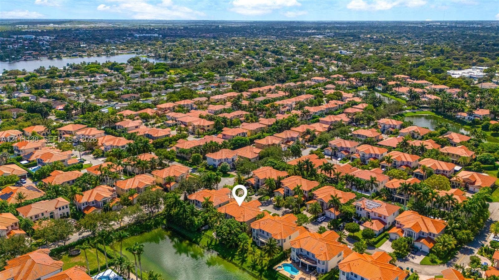 19363 SW 79th Avenue, Cutler Bay, FL 33157 Aerial perspective highlighting a residential property featuring a tile roof, paved driveway, and proximity to neighborhood lakes and tropical landscaping