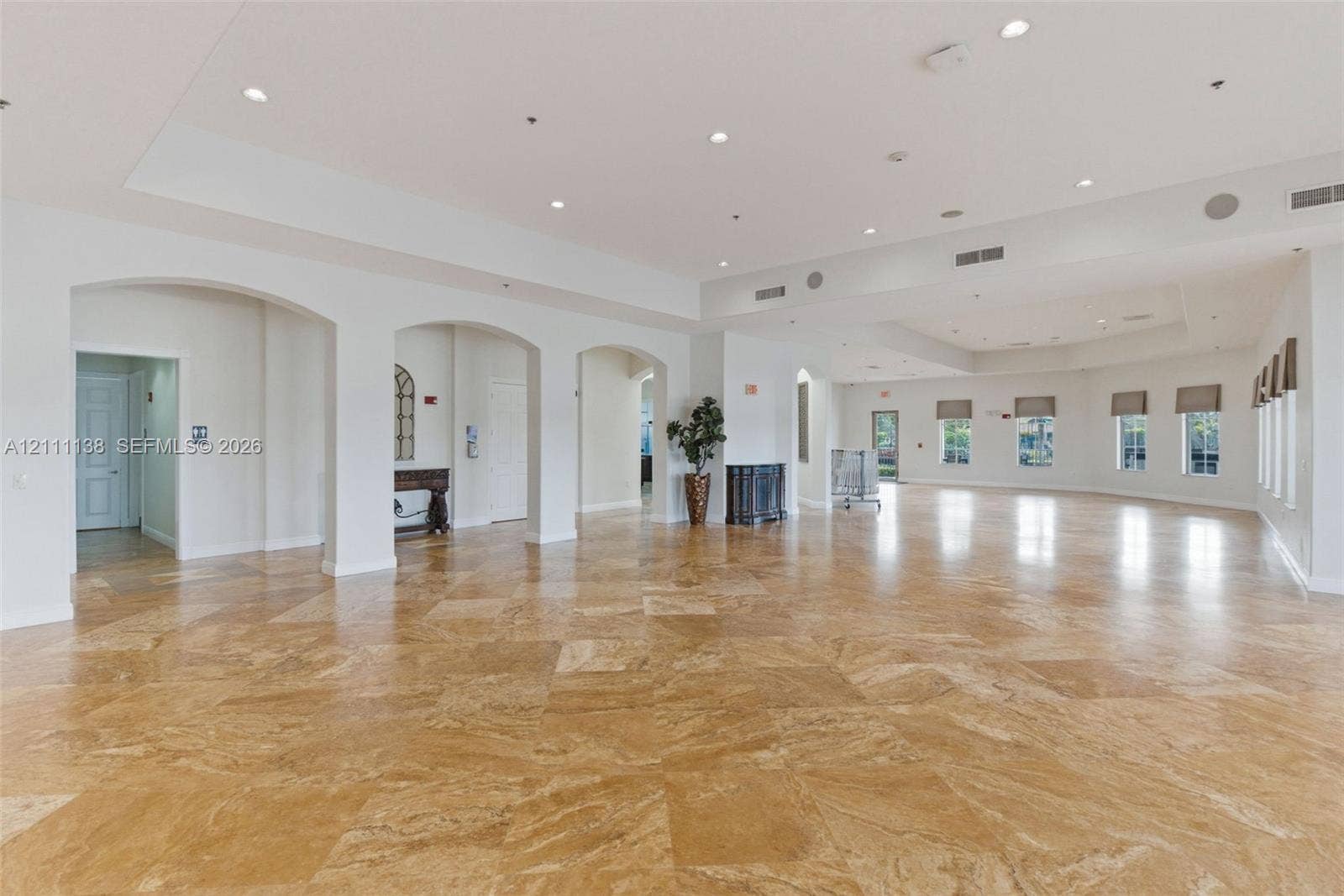 19363 SW 79th Avenue, Cutler Bay, FL 33157 Expansive interior featuring large-format stone flooring, recessed ceiling lighting, multiple architectural archways, and oversized windows