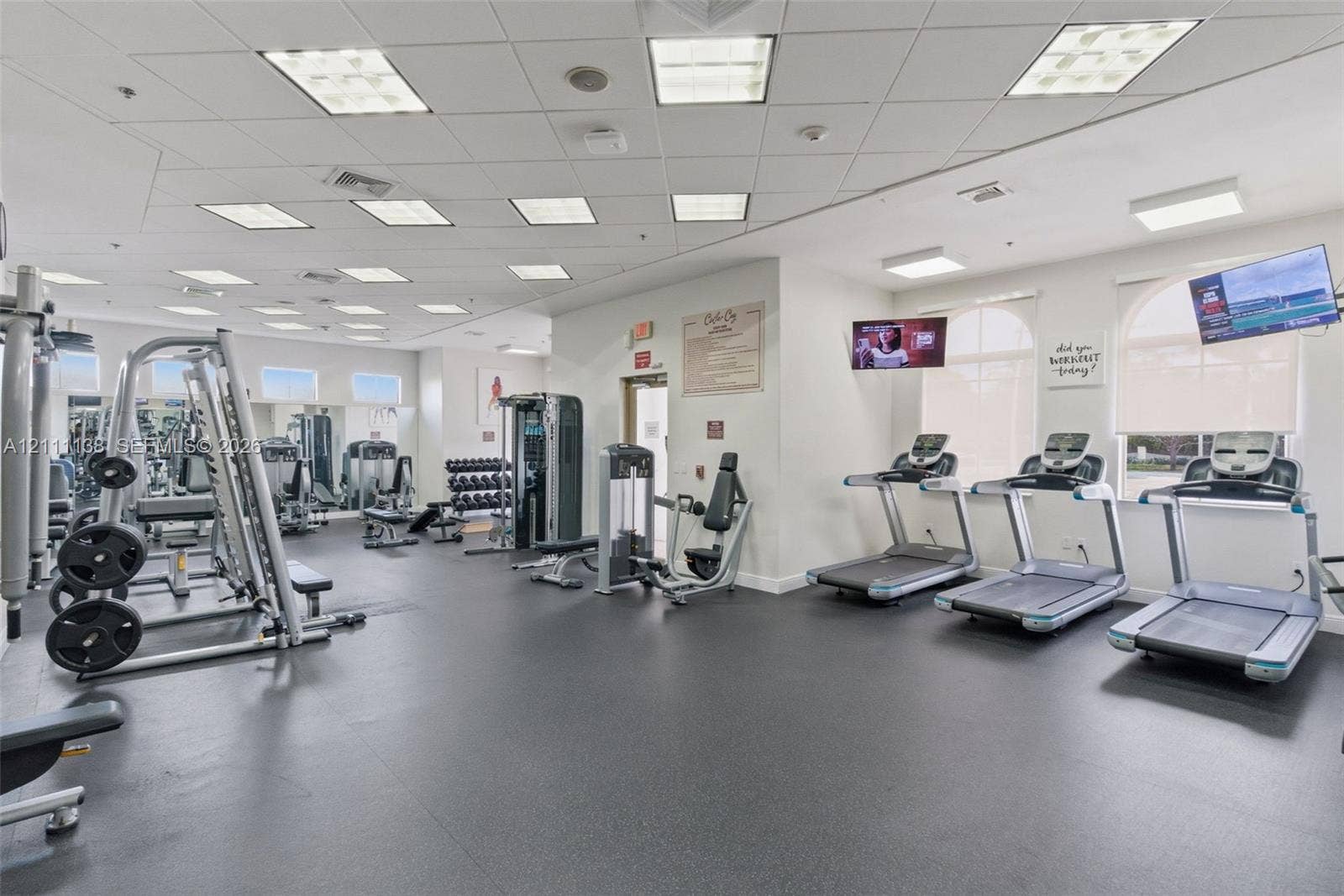 19363 SW 79th Avenue, Cutler Bay, FL 33157 Fitness facility featuring rubberized flooring, recessed grid lighting, multiple treadmills, and wall-mounted televisions
