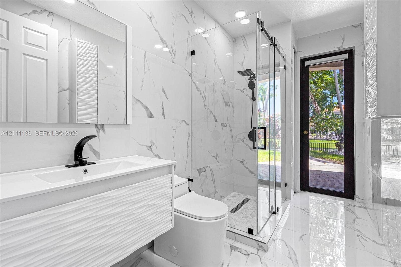 19363 SW 79th Avenue, Cutler Bay, FL 33157 Bathroom featuring floor-to-ceiling porcelain tile, a glass-enclosed walk-in shower with matte black fixtures, a textured vanity cabinet, and a recessed medicine cabinet