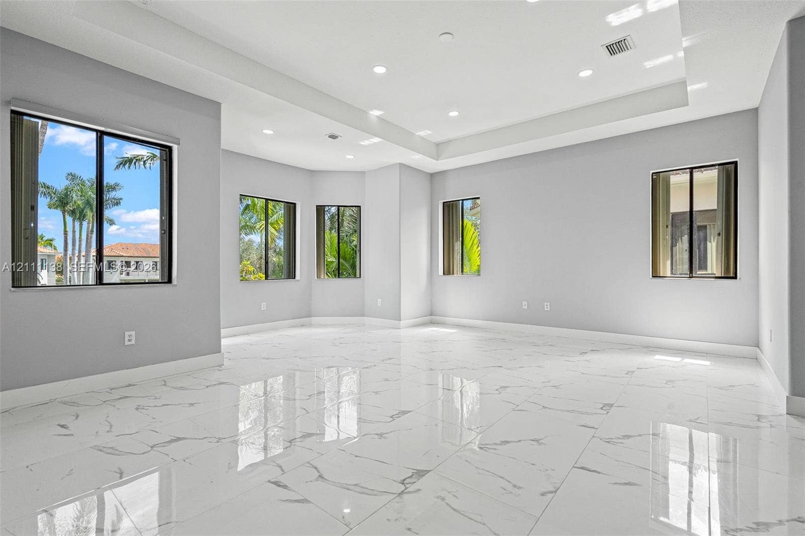 19363 SW 79th Avenue, Cutler Bay, FL 33157 Spacious room featuring high-gloss large-format porcelain tile flooring, recessed ceiling lighting, a tray ceiling, and multiple windows