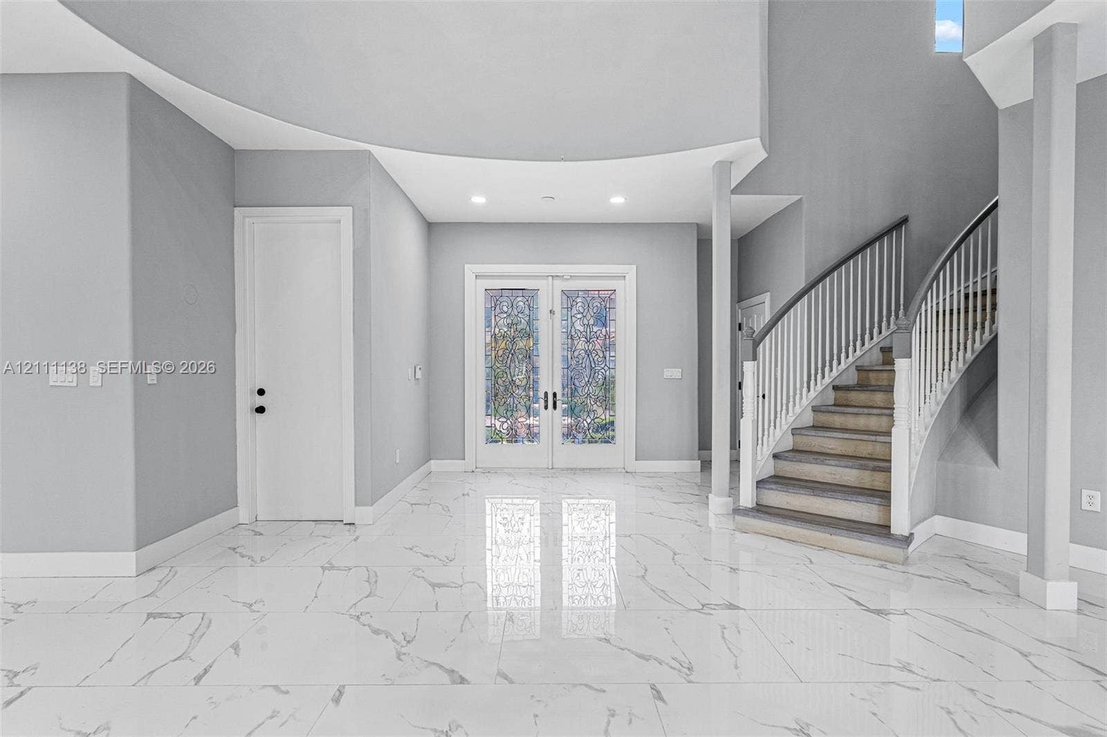 19363 SW 79th Avenue, Cutler Bay, FL 33157 Foyer featuring large-format veined tile flooring, a curved staircase with white spindles, high ceilings with recessed lighting, and double-entry doors