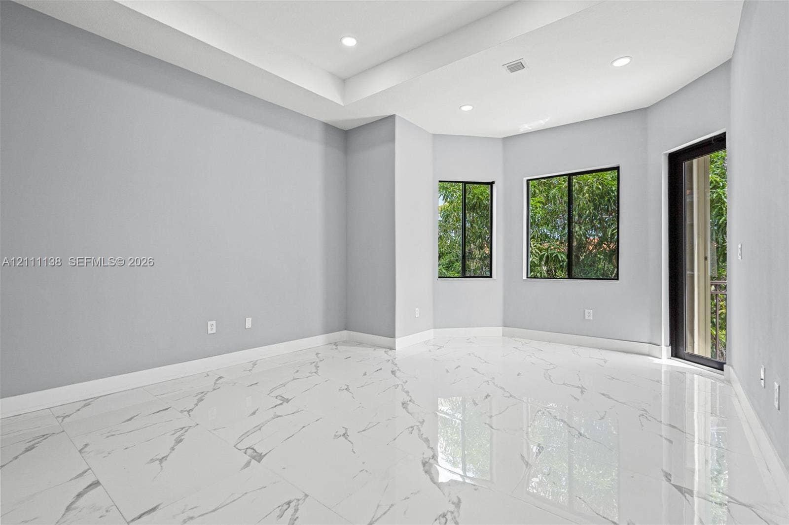 19363 SW 79th Avenue, Cutler Bay, FL 33157 Polished tile flooring with marble-pattern veining, tray ceiling, recessed lighting, and large-paned windows
