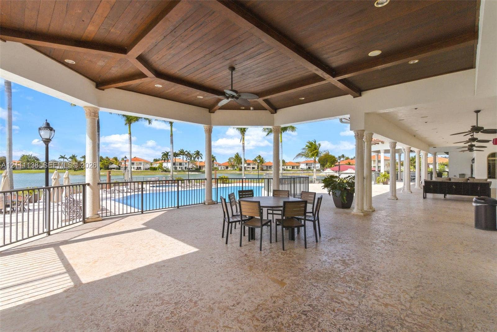 19363 SW 79th Avenue, Cutler Bay, FL 33157 Covered lanai featuring a vaulted wood-plank ceiling, structural columns, recessed lighting, ceiling fans, and stone-finish flooring