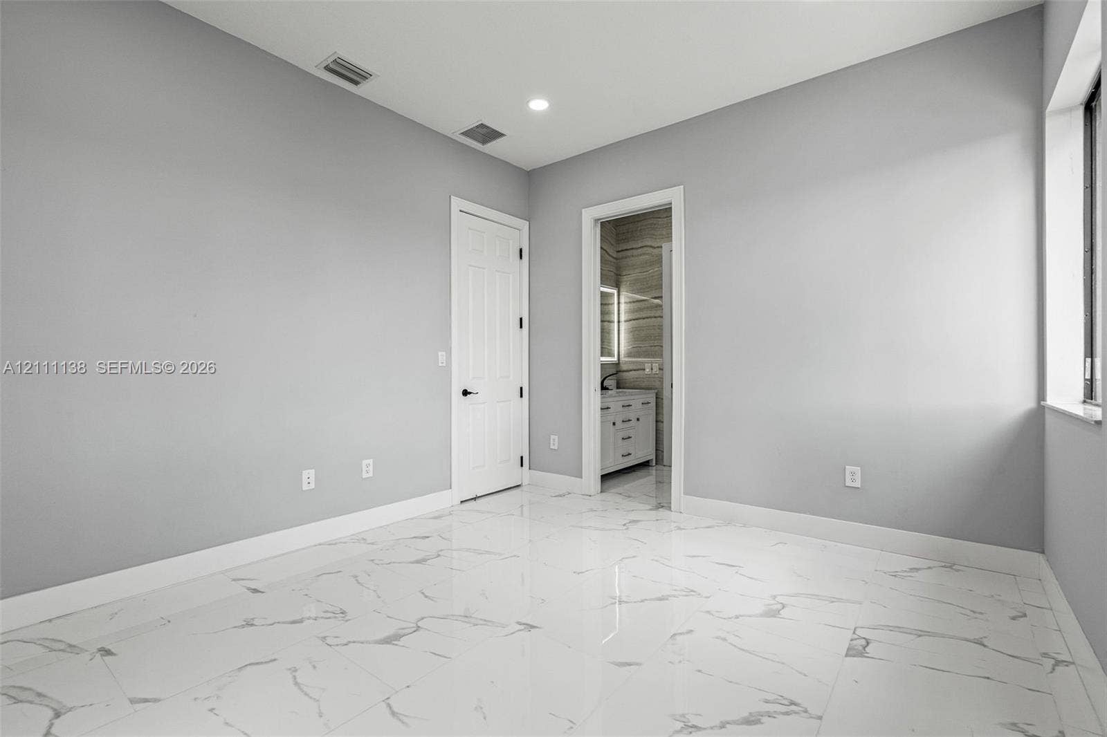19363 SW 79th Avenue, Cutler Bay, FL 33157 Polished stone-finish flooring with large-format veining, recessed lighting, and a multi-panel door