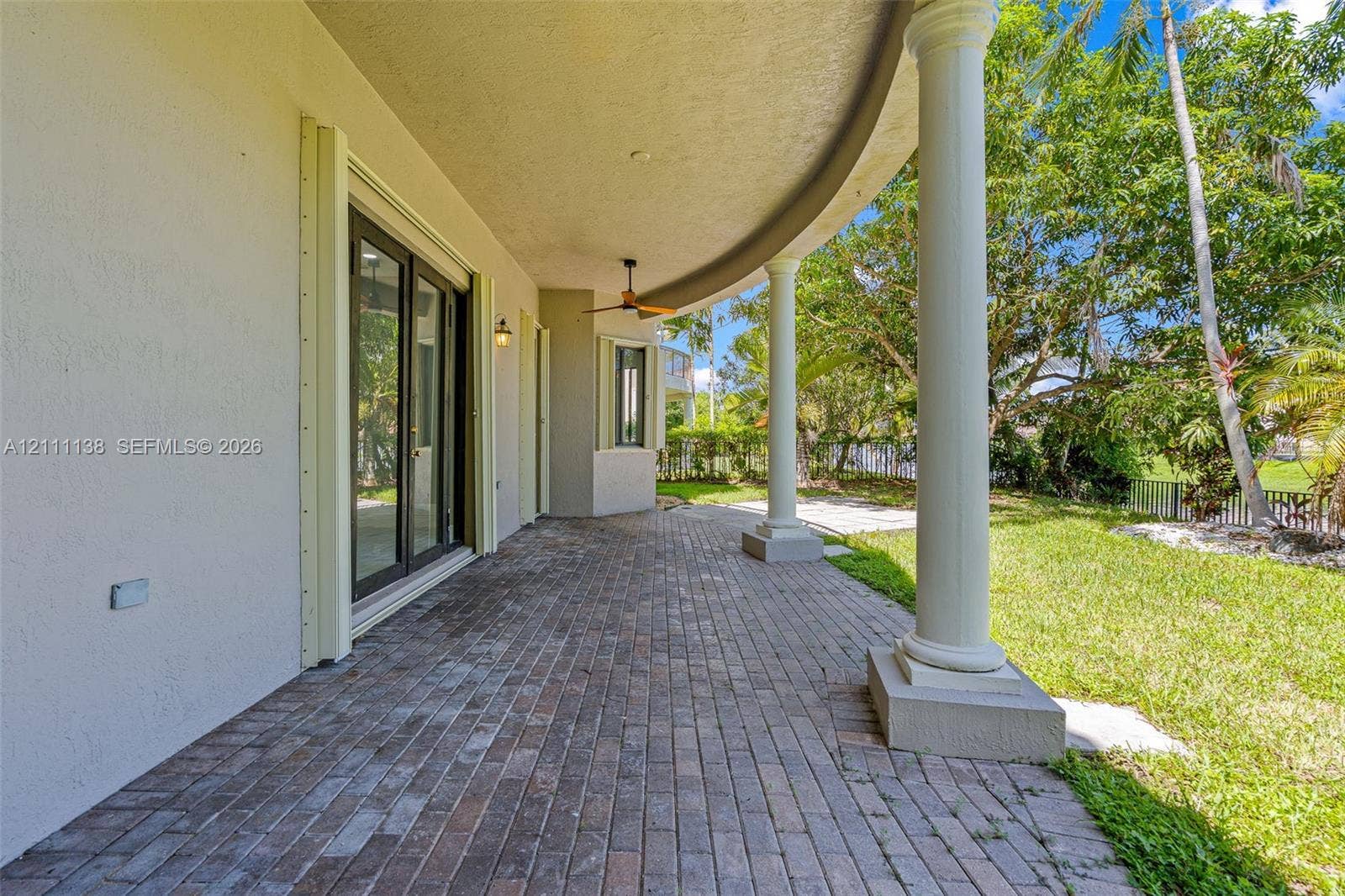 19363 SW 79th Avenue, Cutler Bay, FL 33157 Covered curved patio featuring brick pavers, classical columns, and a ceiling-mounted fan