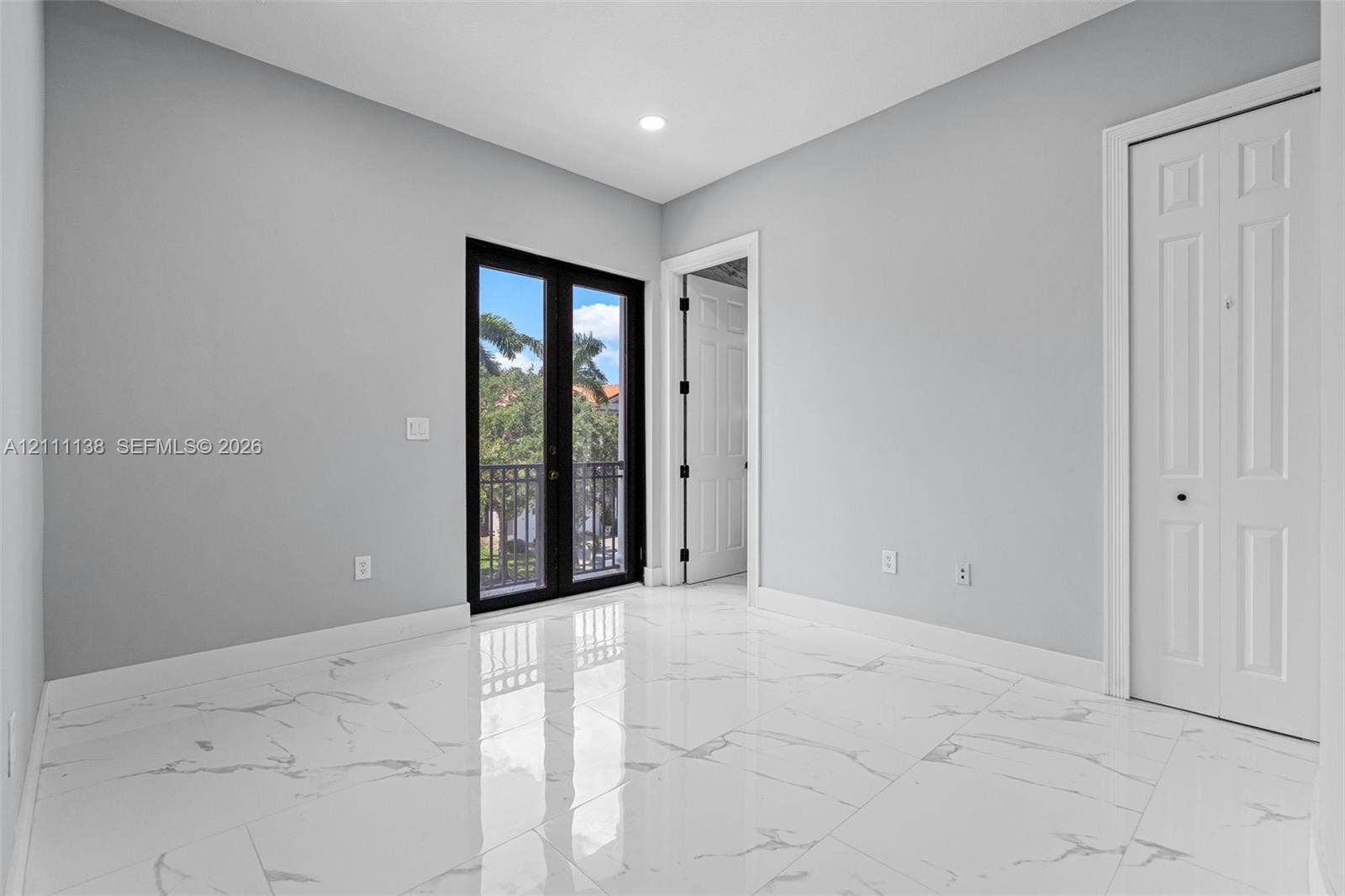 19363 SW 79th Avenue, Cutler Bay, FL 33157 Large-format tile flooring with a veined pattern, recessed ceiling lighting, black-framed French doors, and a double-door closet with paneled detailing