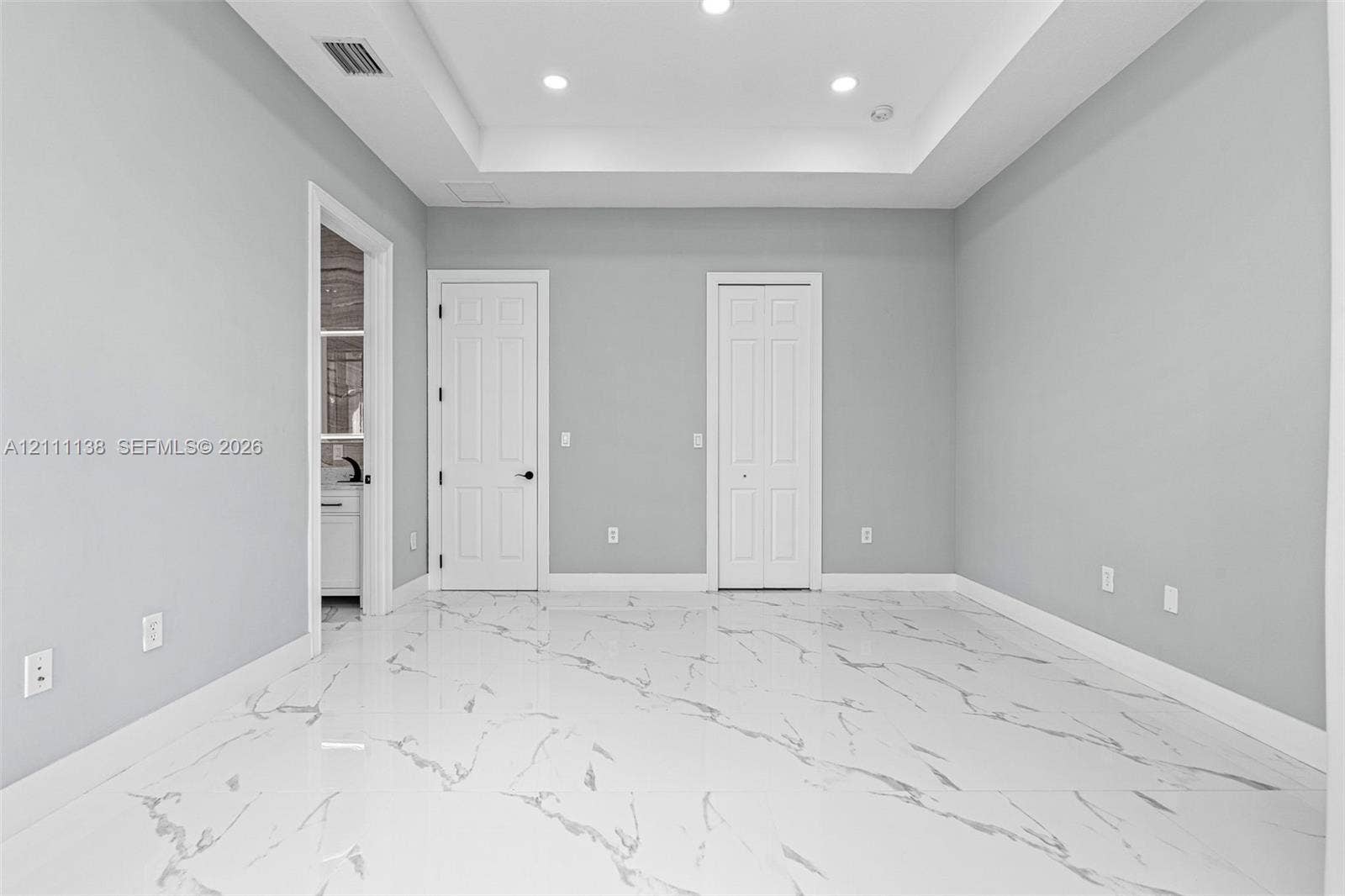 19363 SW 79th Avenue, Cutler Bay, FL 33157 Interior space featuring a recessed tray ceiling, large-format stone-patterned tile flooring, and integrated recessed lighting