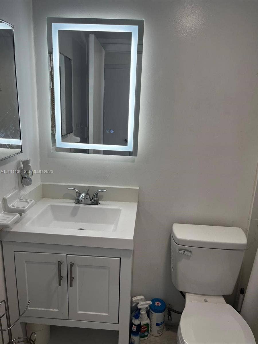 1333 E Hallandale Beach Boulevard, #236, Hallandale Beach, Hallandale Beach, FL 33009 White vanity with a rectangular integrated sink, chrome dual-handle faucet, and illuminated LED-bordered mirror