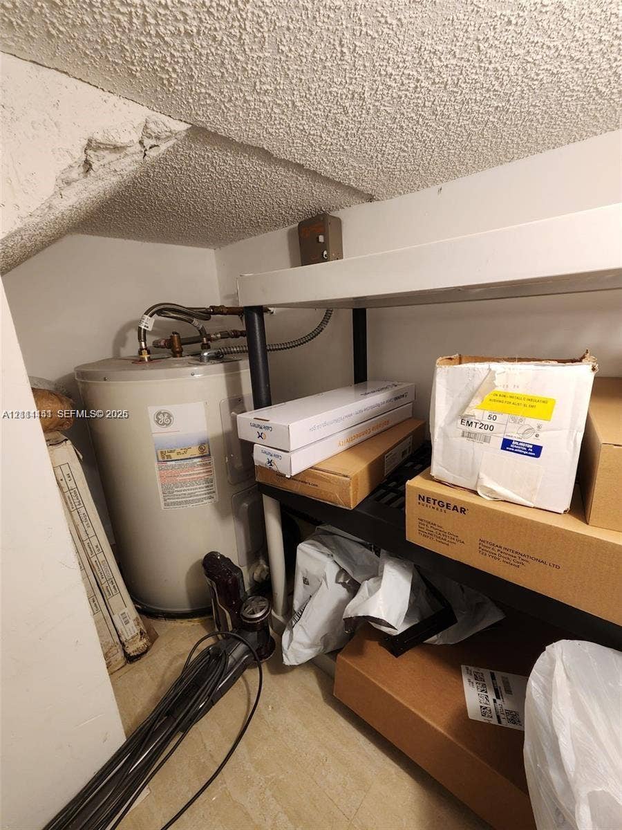 Utility area featuring a water heater and structural ceiling finish