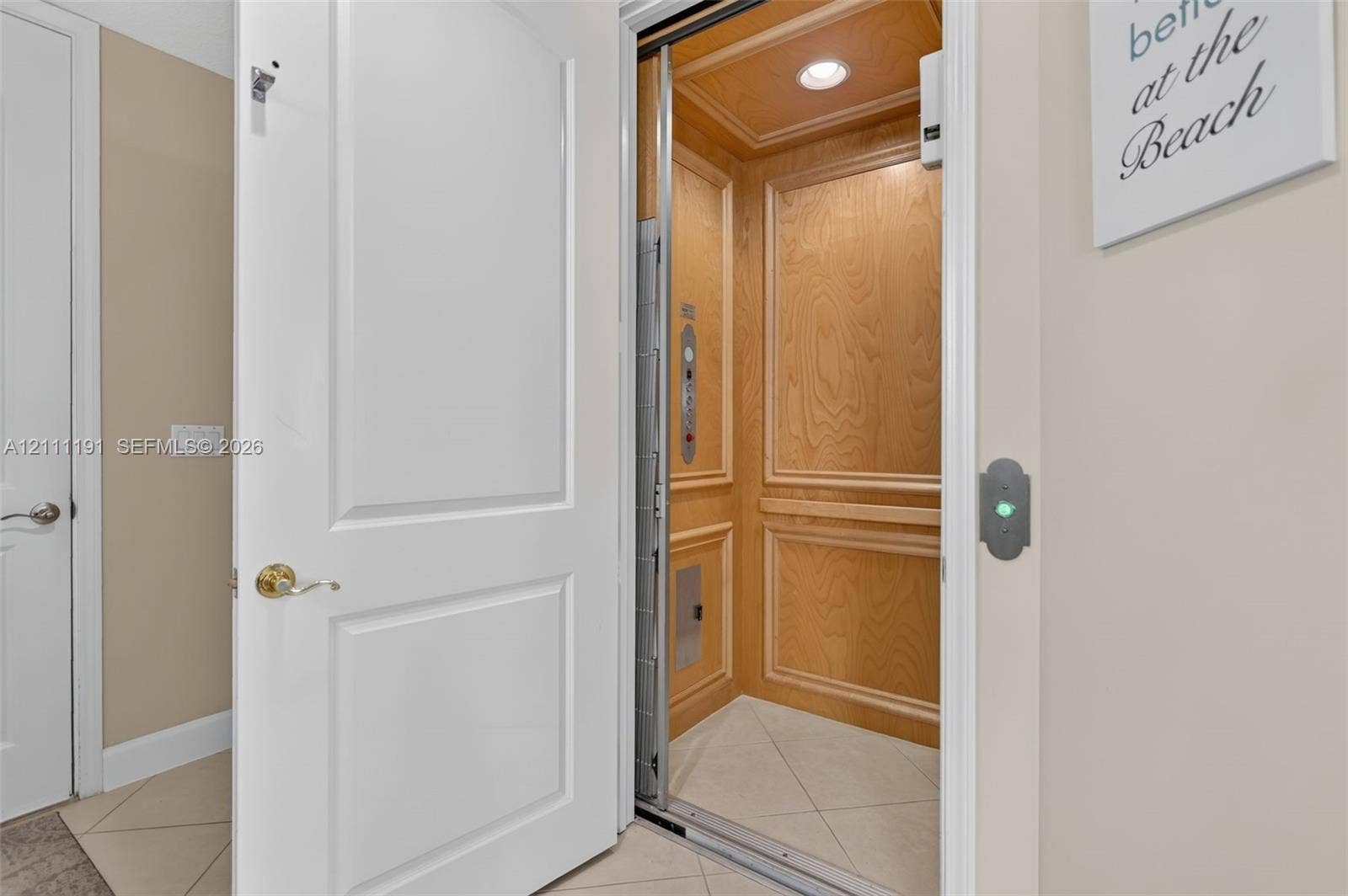 Private home elevator conveniently located upon entering home thru front door or garage featuring wood-paneled walls, recessed ceiling lighting, and tile flooring