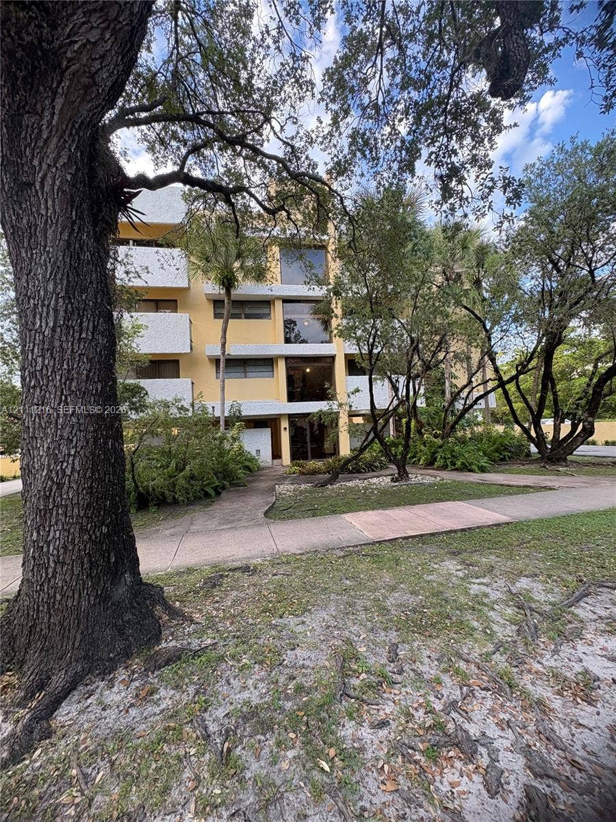 525 Coral Way, #303, Coral Gables, Coral Gables, FL 33134 Multi-story building exterior featuring concrete construction, stackable balconies, large glass windows, and mature shade trees