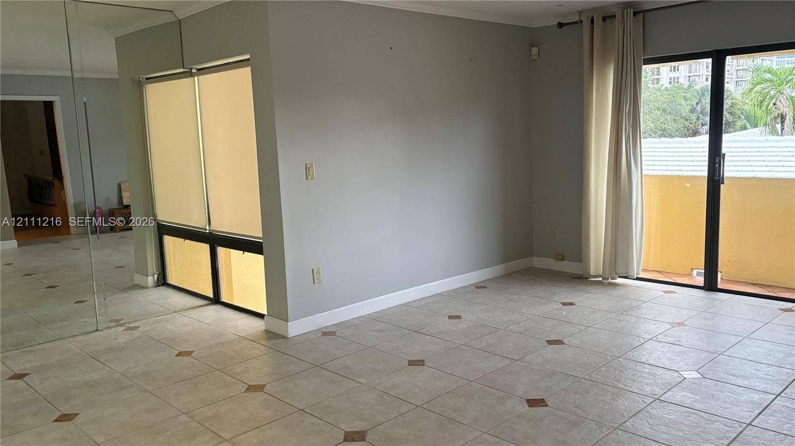 525 Coral Way, #303, Coral Gables, Coral Gables, FL 33134 Living area featuring large-format tile flooring with decorative inlay accents, expansive wall-to-wall mirror paneling, fixed window panes with integrated blinds, and a sliding glass door providing external access