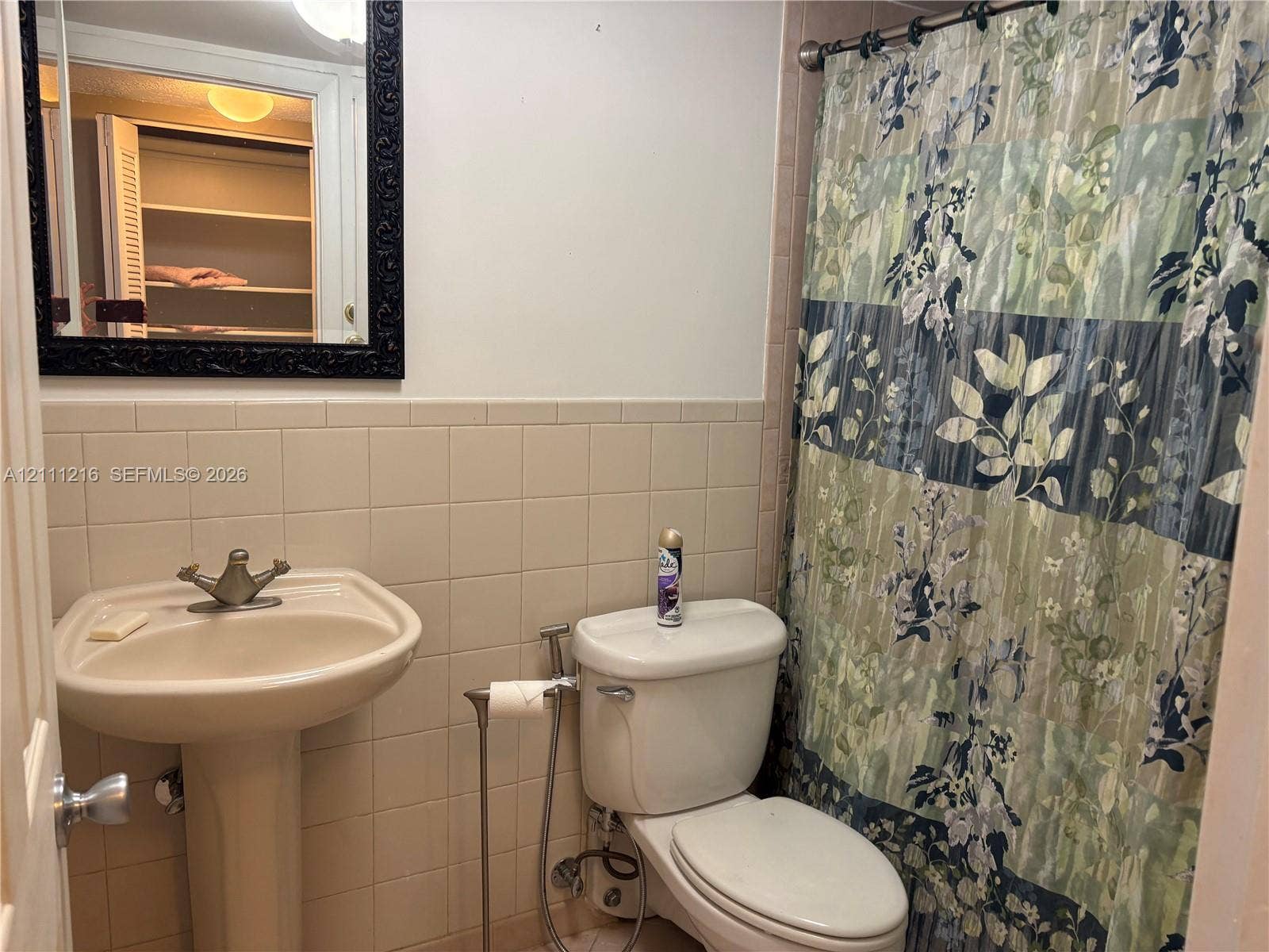 525 Coral Way, #303, Coral Gables, Coral Gables, FL 33134 Bathroom featuring a pedestal sink with a metallic faucet, ceramic tile backsplash, and a wall-mounted mirror