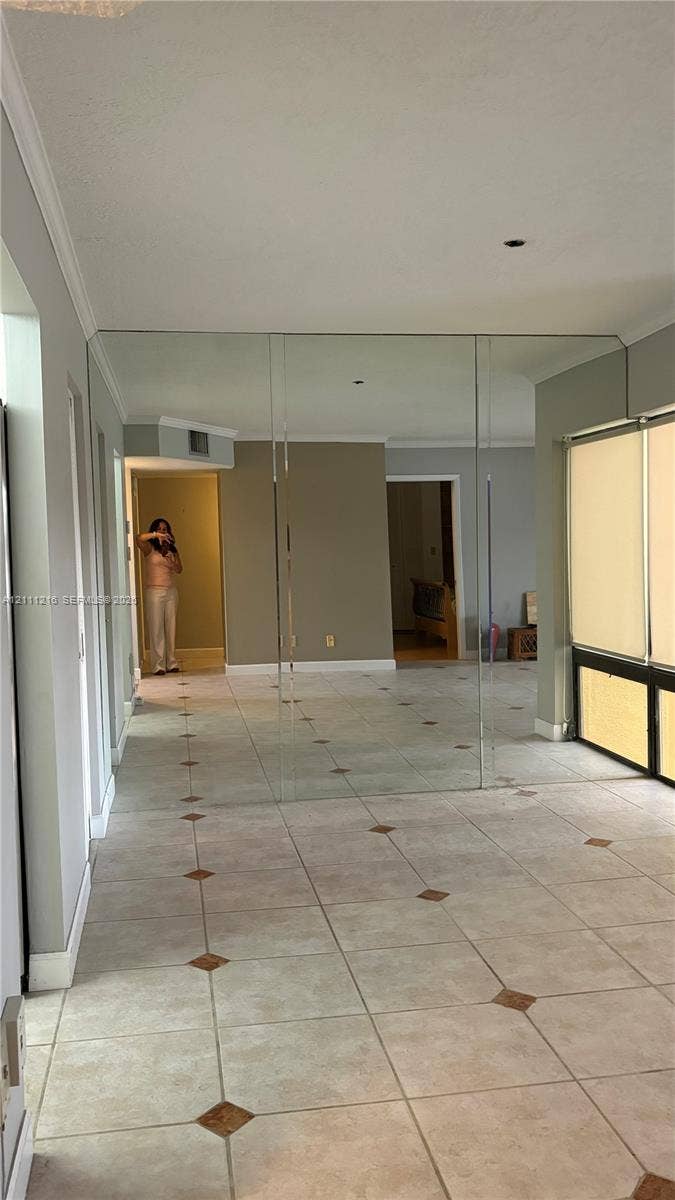 525 Coral Way, #303, Coral Gables, Coral Gables, FL 33134 Tile flooring with decorative inset accents, wall-to-wall mirrored paneling, and large windows with horizontal blinds