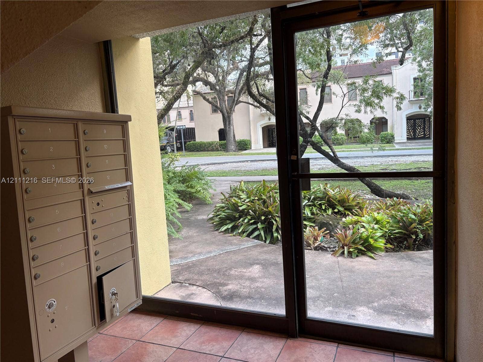 525 Coral Way, #303, Coral Gables, Coral Gables, FL 33134 Covered entryway featuring tile flooring, metal mail collection station, and a full-light glass door