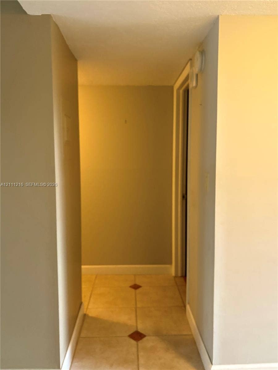525 Coral Way, #303, Coral Gables, Coral Gables, FL 33134 Hallway featuring neutral-toned walls and ceramic tile flooring with decorative inlay accents