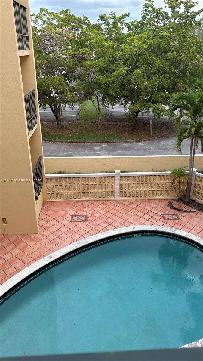 525 Coral Way, #303, Coral Gables, Coral Gables, FL 33134 Outdoor swimming pool featuring a tiled deck area and a decorative concrete block privacy wall