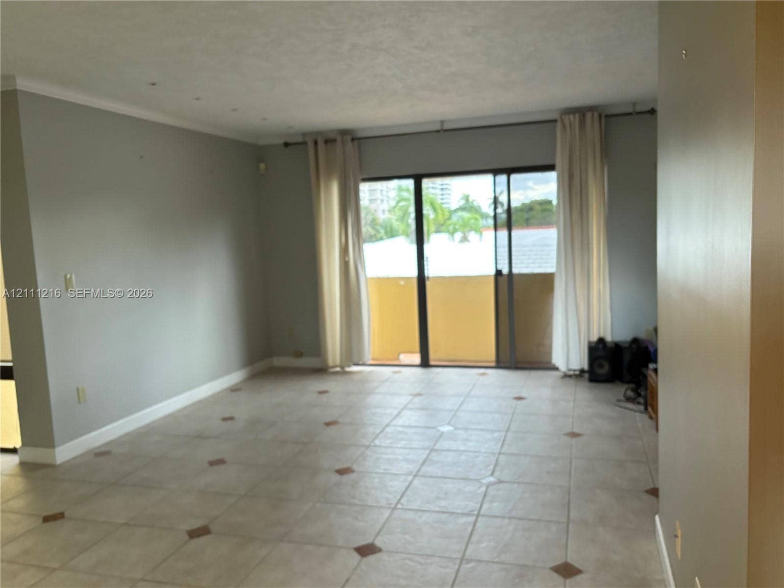 525 Coral Way, #303, Coral Gables, Coral Gables, FL 33134 Open living area featuring neutral tile flooring with inlay accents, recessed ceiling lighting, and sliding glass doors providing outdoor access