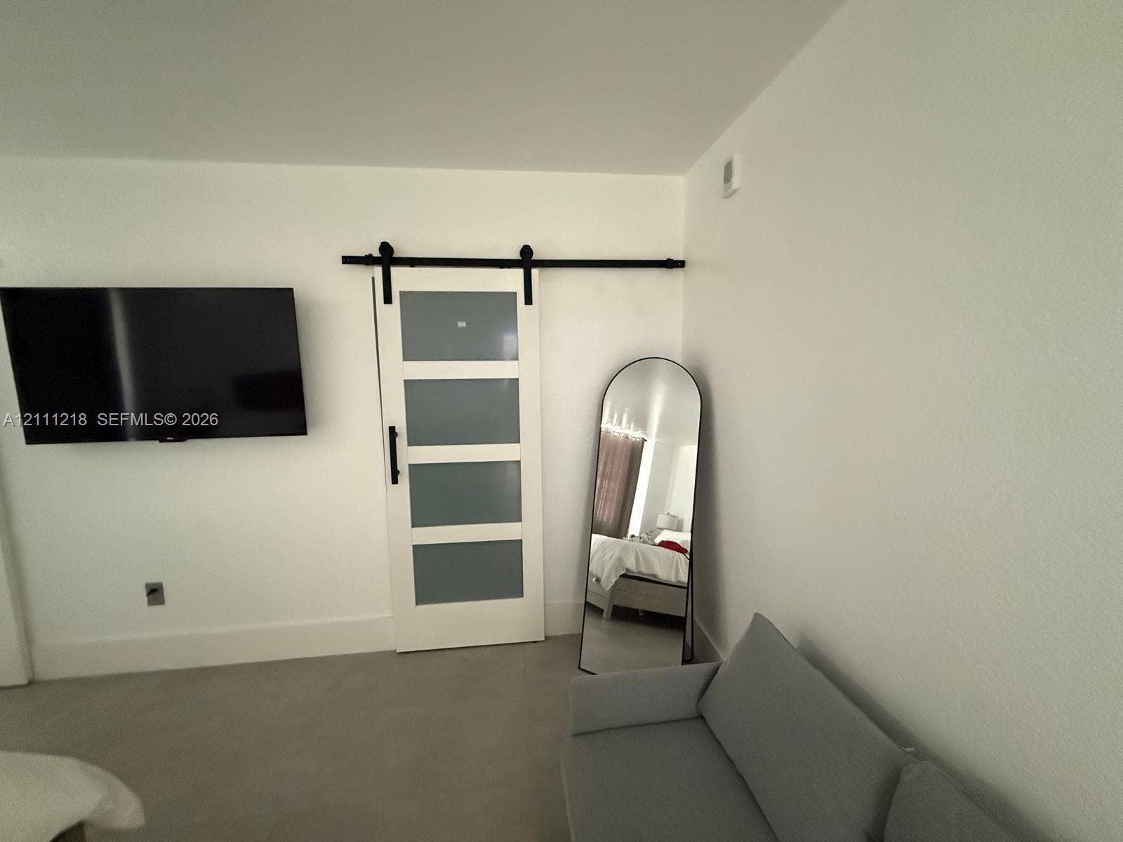 White interior door featuring frosted glass panels and a black metal sliding barn door track system