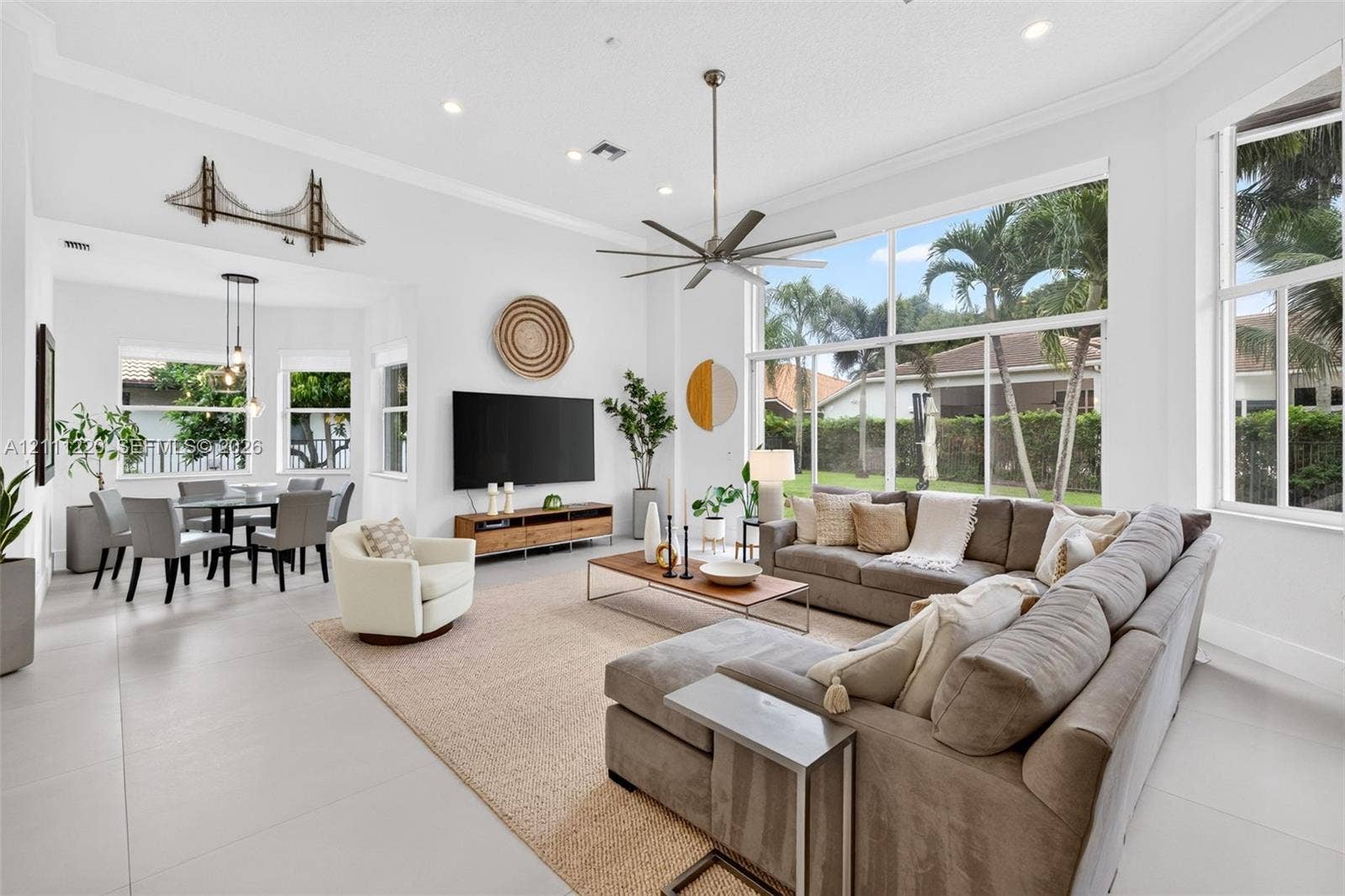 134 Dockside Terrace, Weston, FL 33327 Expansive living space featuring soaring ceilings, floor-to-ceiling windows, uniform tile flooring, recessed lighting, and a multi-blade ceiling fan