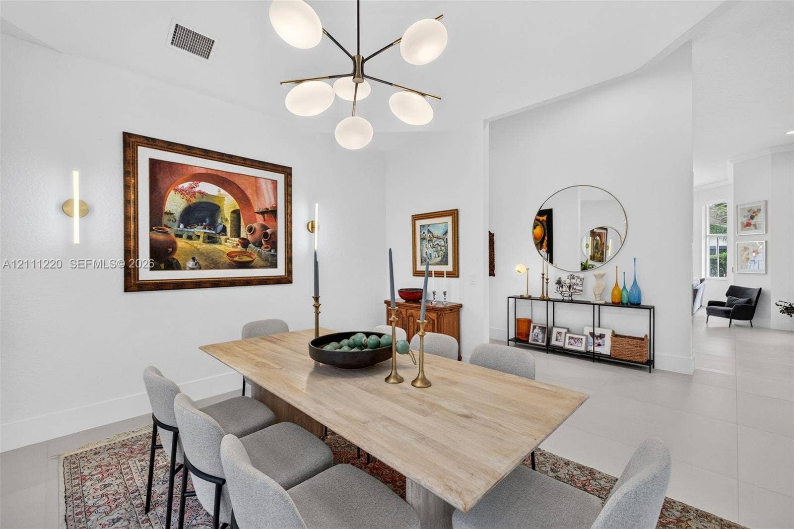 134 Dockside Terrace, Weston, FL 33327 Multi-arm contemporary chandelier with opal glass shades, neutral large-format tile flooring, and integrated wall-mounted linear light fixtures