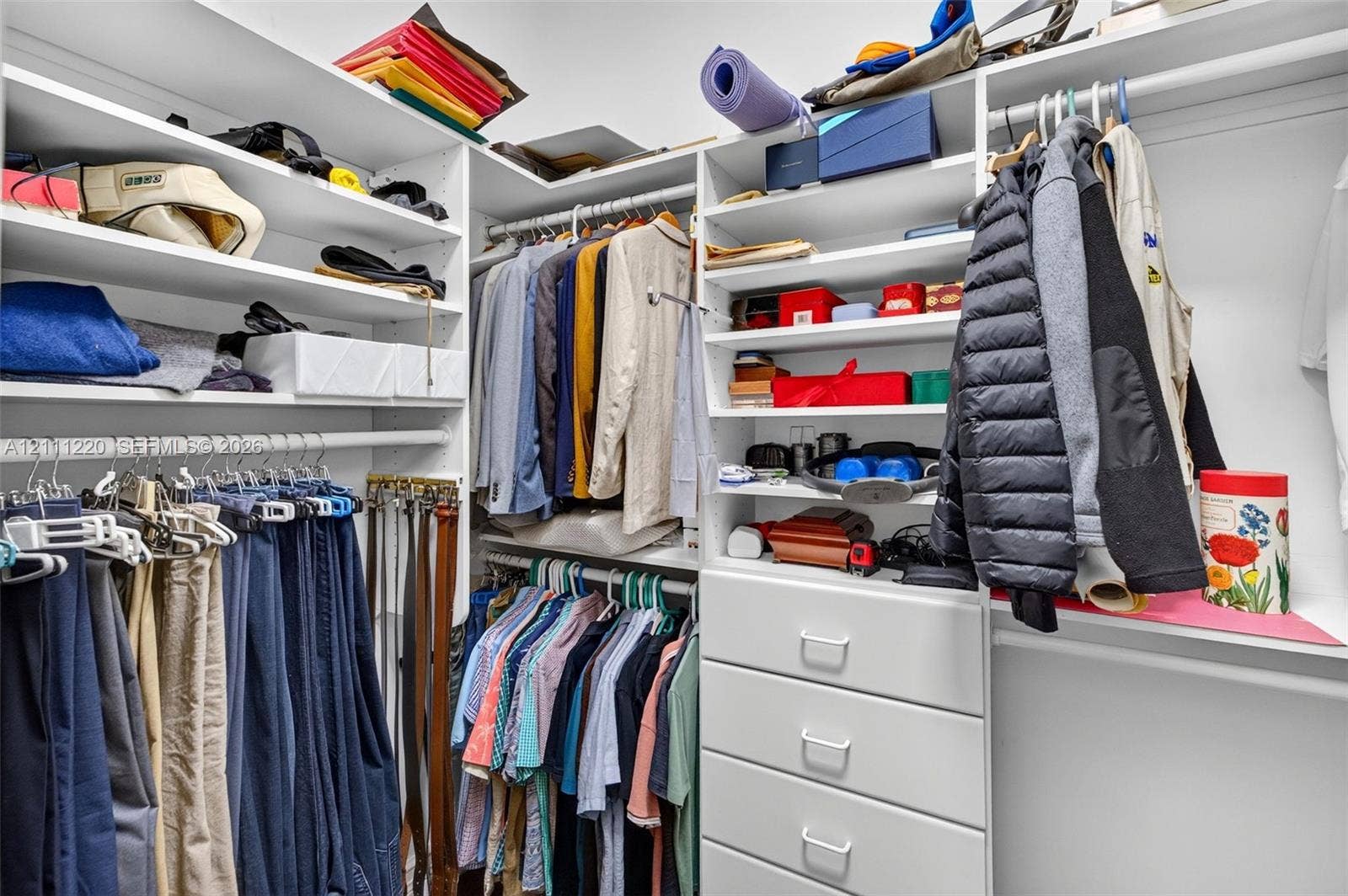 134 Dockside Terrace, Weston, FL 33327 Walk-in closet featuring white built-in shelving, multi-level clothing rods, and a stack of four integrated storage drawers