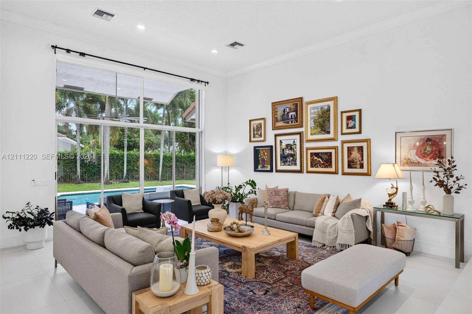134 Dockside Terrace, Weston, FL 33327 High-ceiling living area featuring floor-to-ceiling glass panel windows, recessed lighting, and large-format tile flooring
