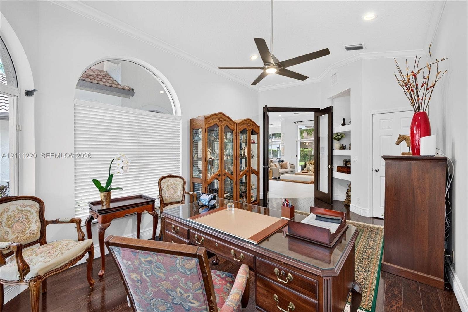 134 Dockside Terrace, Weston, FL 33327 Room featuring arched windows, dark wood-finish flooring, built-in recessed shelving, and a ceiling fan