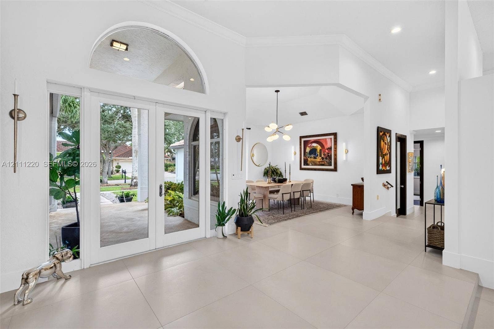 134 Dockside Terrace, Weston, FL 33327 Foyer featuring large-format tile flooring, high ceilings, double glass entry doors with a decorative arch transom window, and crown molding