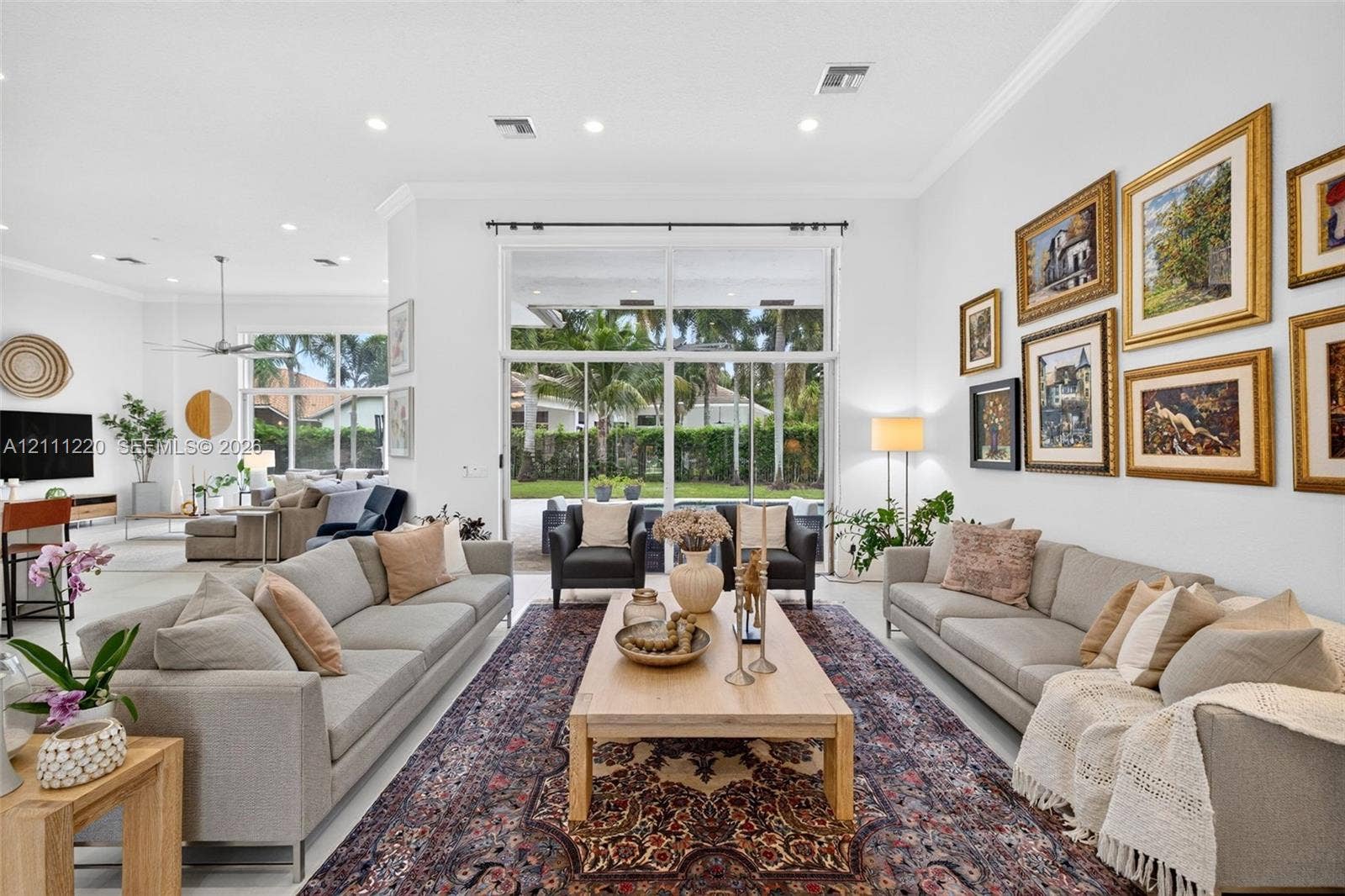 134 Dockside Terrace, Weston, FL 33327 Open-concept interior featuring high ceilings, recessed lighting, neutral tile flooring, and oversized glass sliding doors