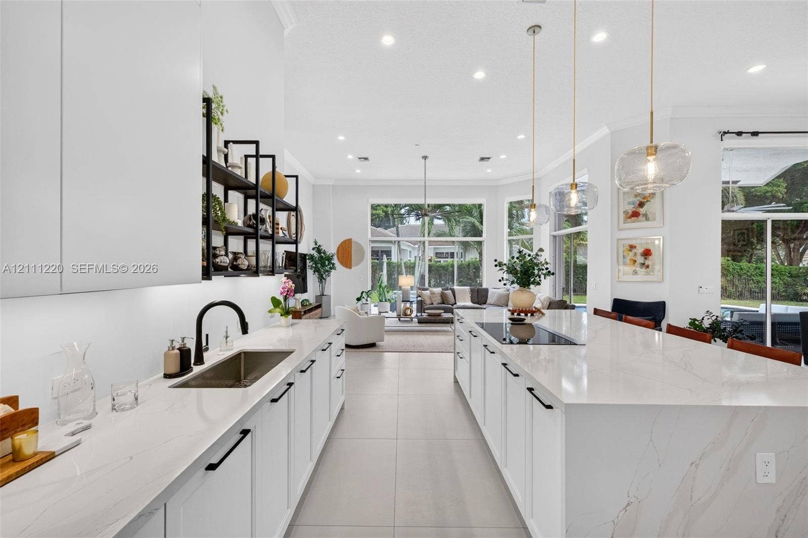 134 Dockside Terrace, Weston, FL 33327 Kitchen featuring expansive central island with quartz surfacing, integrated cooktop, recessed lighting, matte black hardware, and open shelving