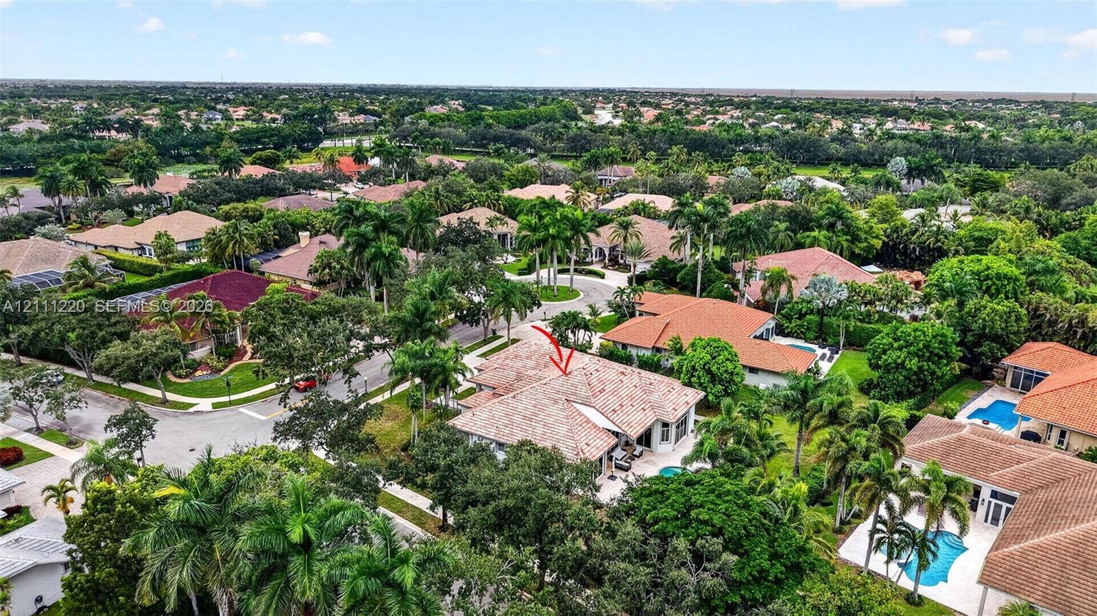 134 Dockside Terrace, Weston, FL 33327 Aerial perspective of a residential property featuring a tiled roof, multi-car garage, and mature landscaping in a suburban setting