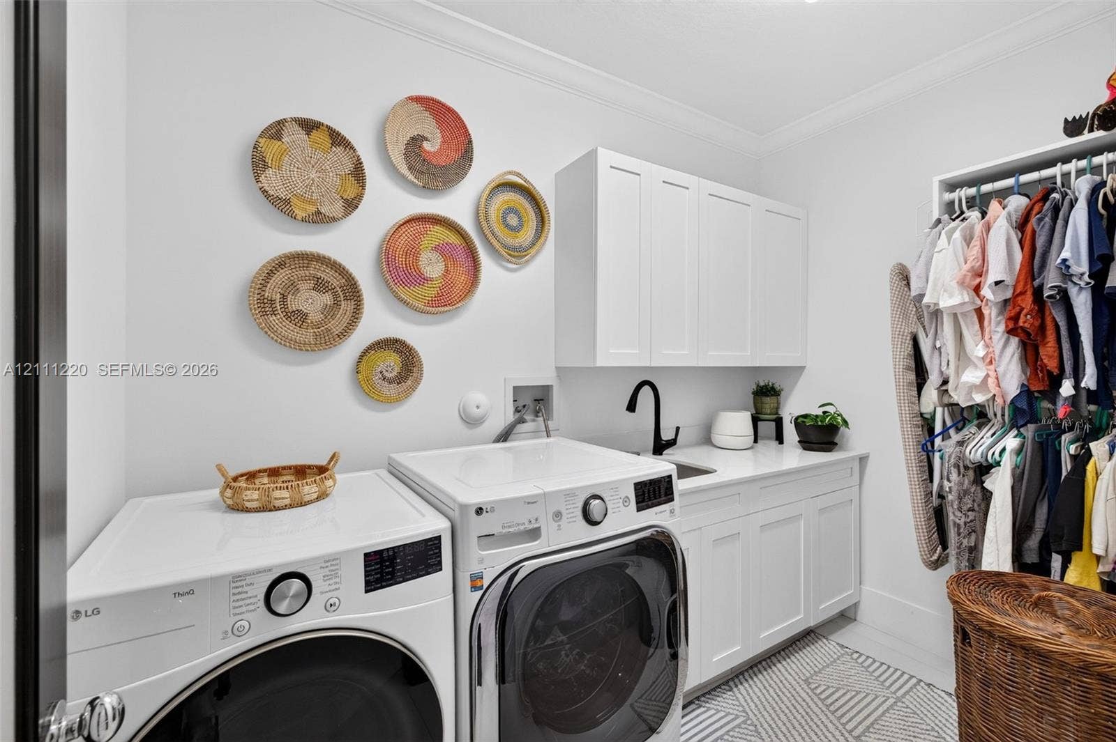 134 Dockside Terrace, Weston, FL 33327 Laundry room featuring shaker-style upper and lower cabinetry, white quartz countertop, undermount sink with a matte black faucet, and patterned tile flooring