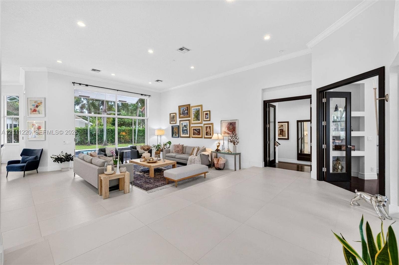 134 Dockside Terrace, Weston, FL 33327 Spacious interior featuring large-format tile flooring, recessed lighting, expansive floor-to-ceiling windows, and French doors with dark-finished trim