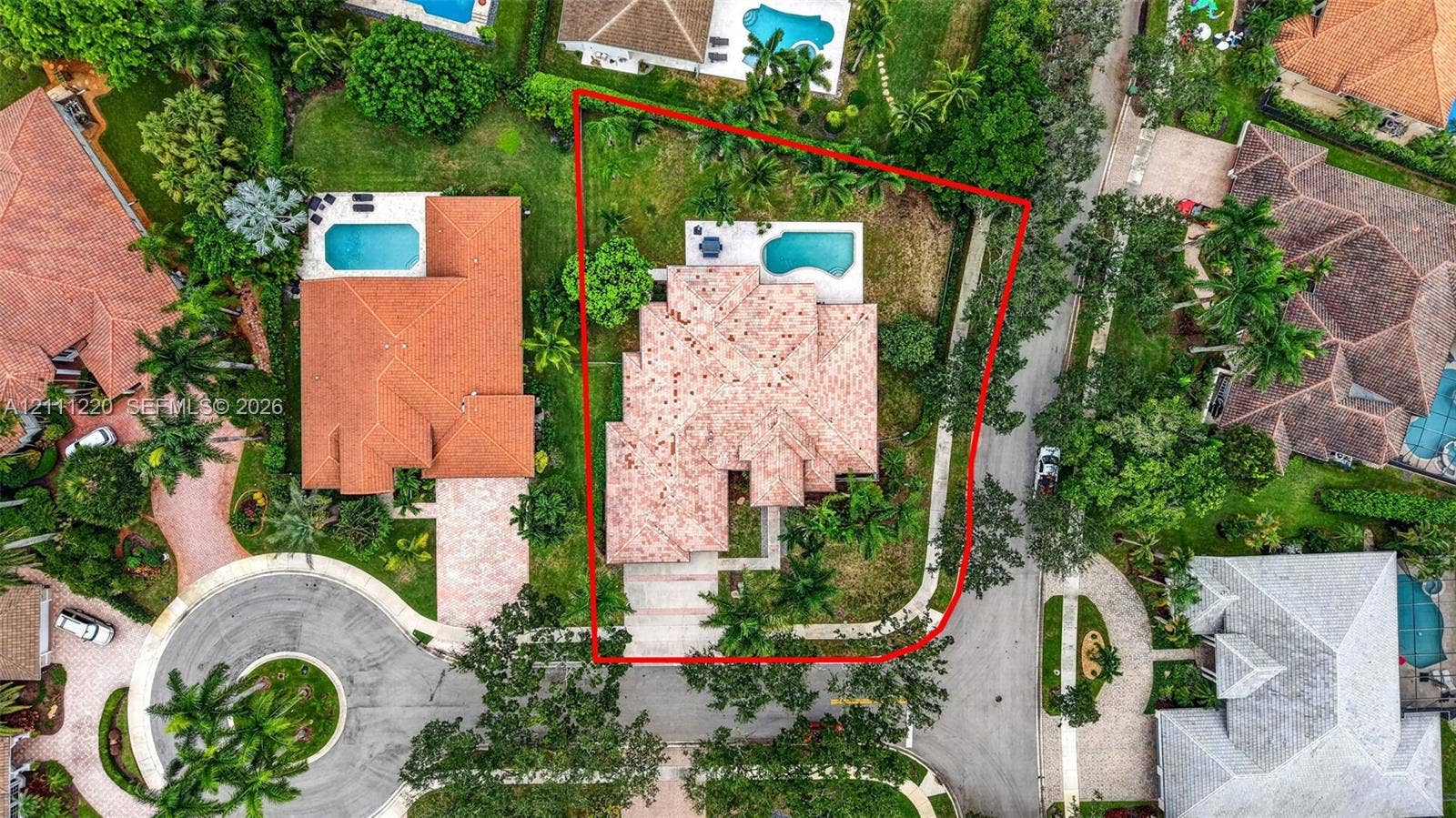134 Dockside Terrace, Weston, FL 33327 Aerial perspective of a property featuring a tiled roof, in-ground swimming pool, concrete driveway, and mature landscaping