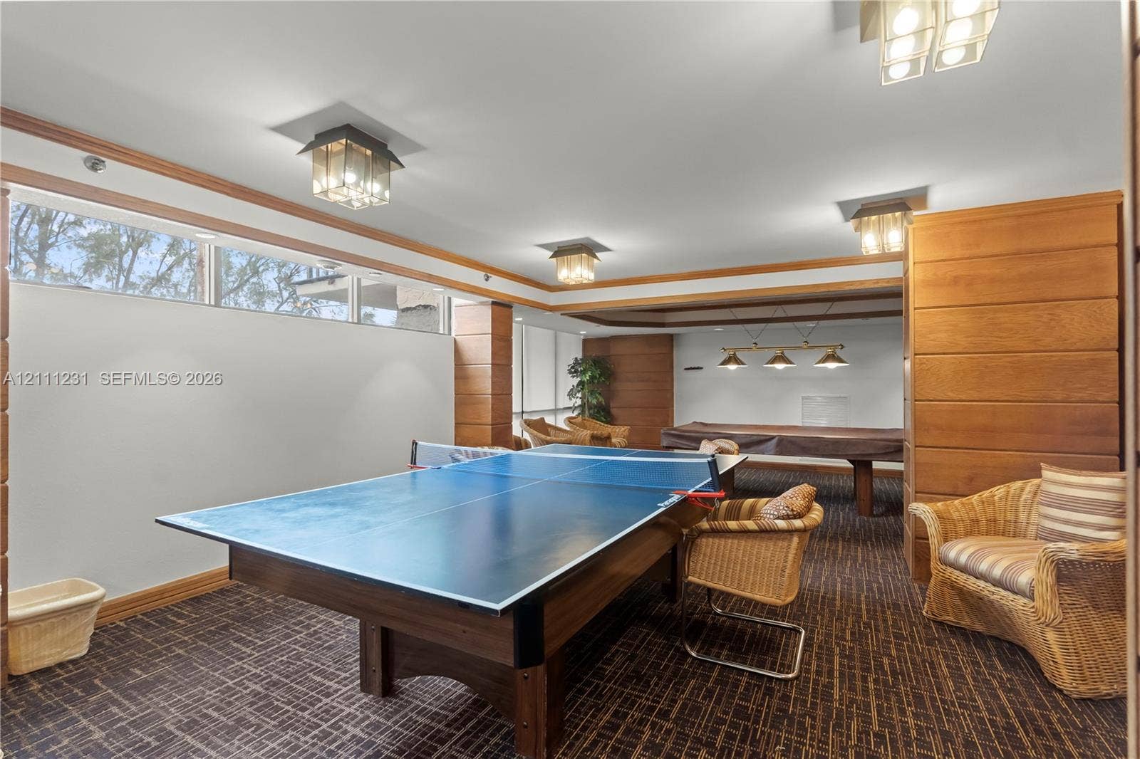 Spacious interior featuring horizontal wood-paneled accent walls, multiple flush-mount glass light fixtures, and a continuous band of clerestory windows