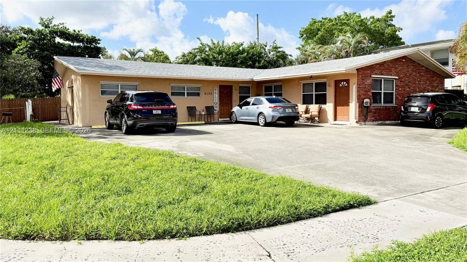 6100 SW 37th Street, Davie, FL 33314 Single-story exterior featuring a stucco and brick facade, hip roof, concrete driveway, and dual entry doors