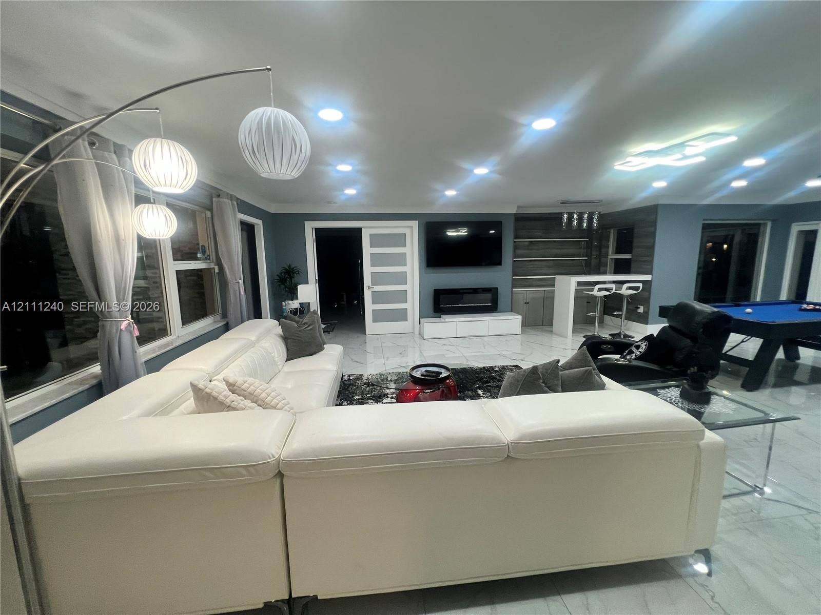 1430 Polk Street, Hollywood, Hollywood, FL 33020 Large format tile flooring, recessed ceiling lighting, wall-mounted electric fireplace, built-in dry bar with shelving, and shaker-style interior door