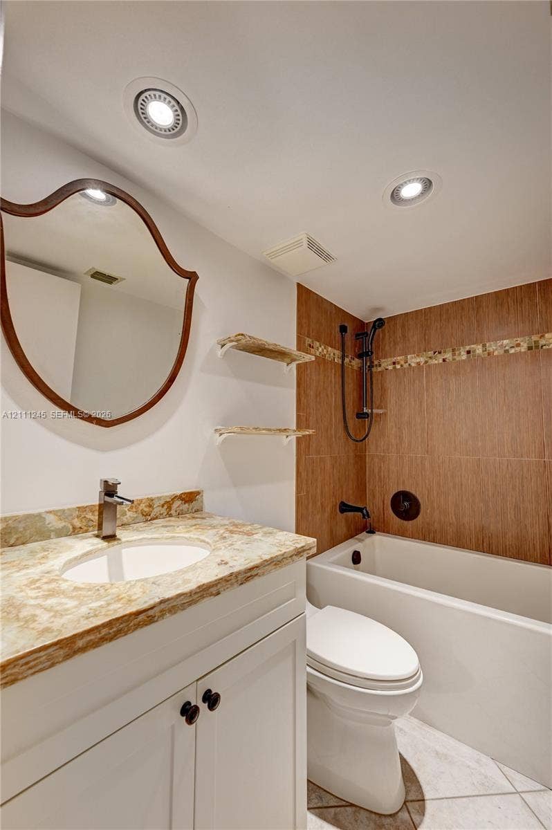 6800 Cypress Road, #506, Plantation, FL 33317 Bathroom featuring a white vanity with a neutral stone countertop, recessed ceiling lighting, wall-mounted open shelving, and a shower-tub combination with wood-finish tile surround and decorative mosaic accent