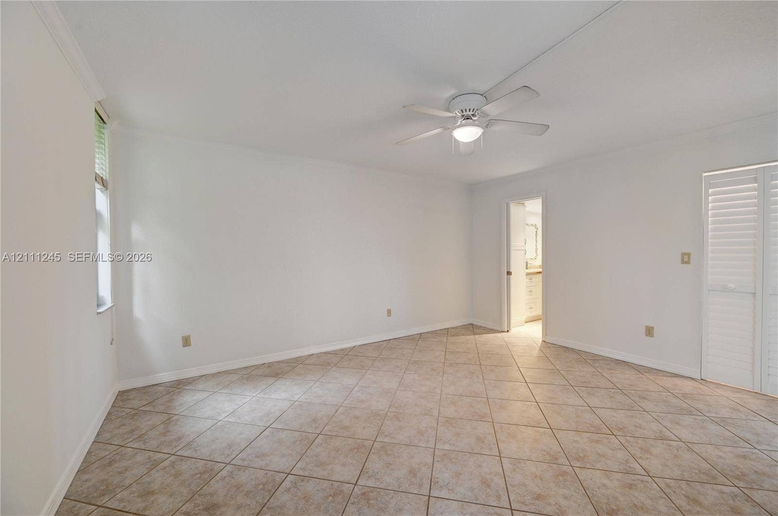6800 Cypress Road, #506, Plantation, FL 33317 Neutral-toned tile flooring, ceiling fan with integrated lighting, and white plantation-style shutters