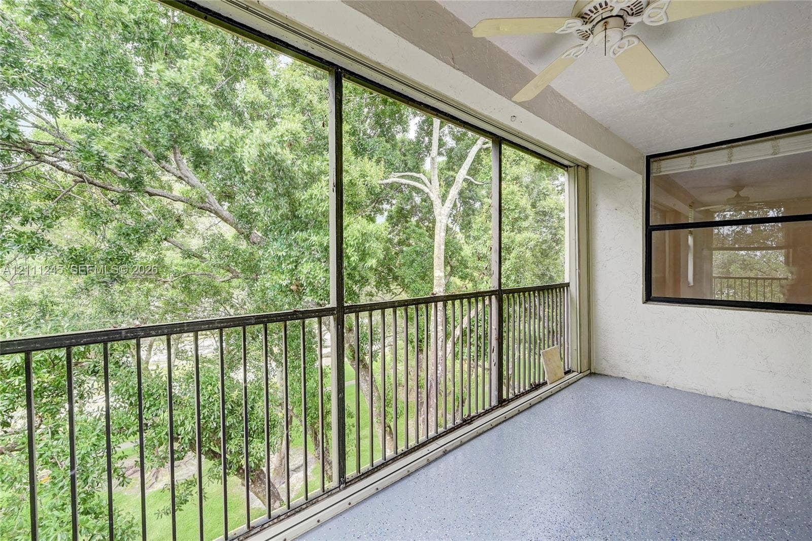 6800 Cypress Road, #506, Plantation, FL 33317 Screened-in balcony featuring metal railings, textured concrete flooring, and a ceiling-mounted fan
