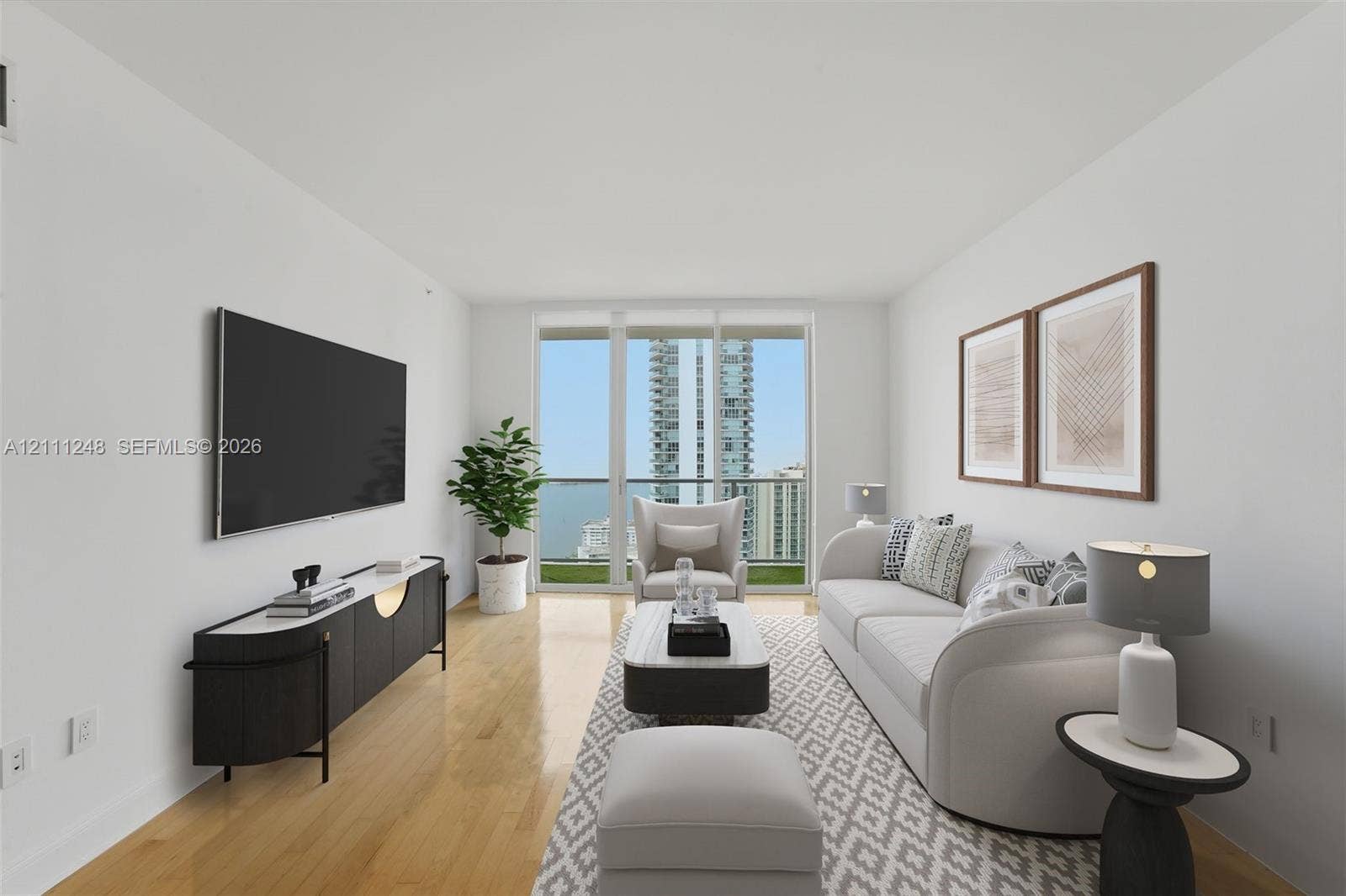 Living area featuring wood-finish flooring, floor-to-ceiling glass panel doors, and access to a private balcony