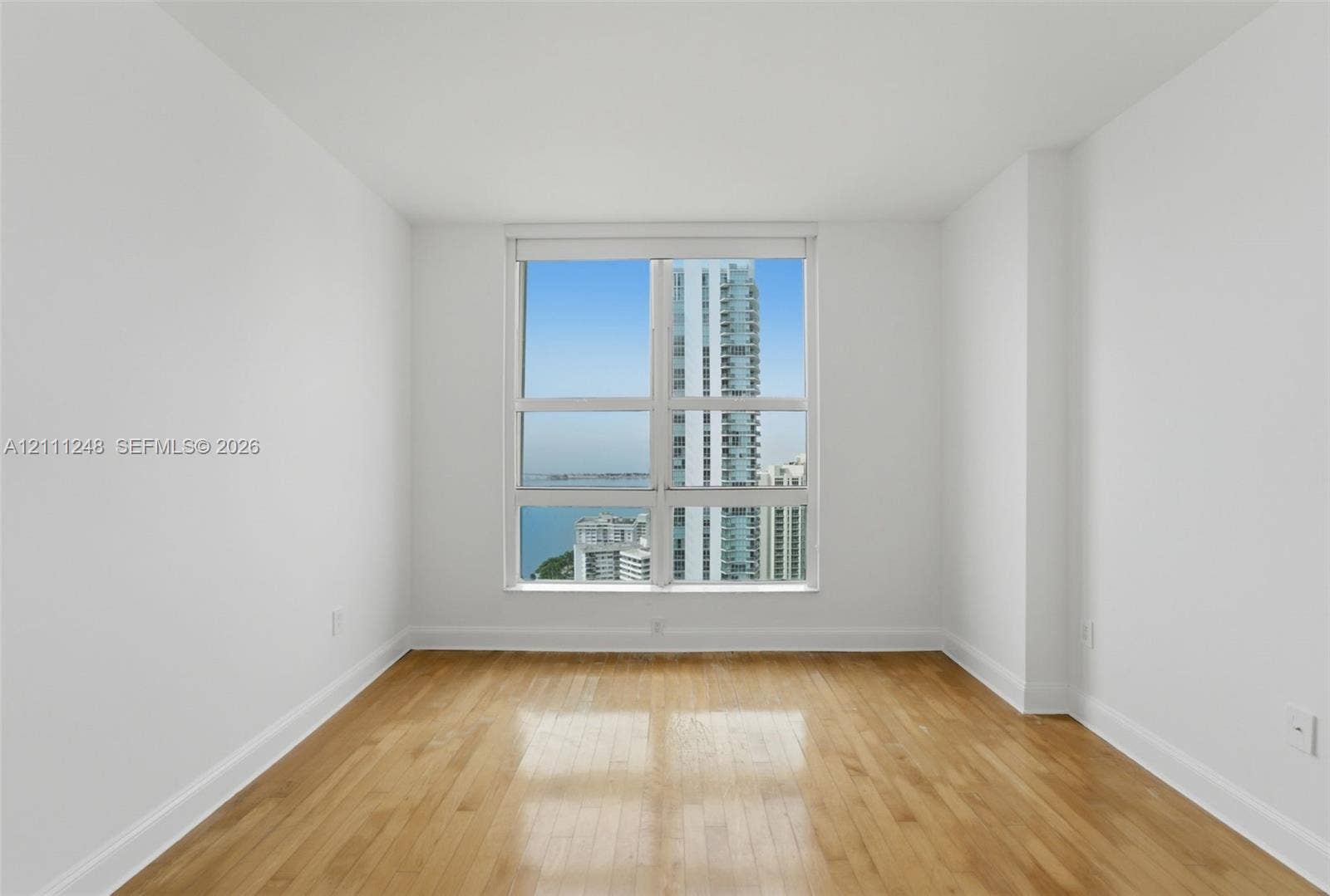 Interior space featuring wood-finish flooring, white walls, and large floor-to-ceiling windows