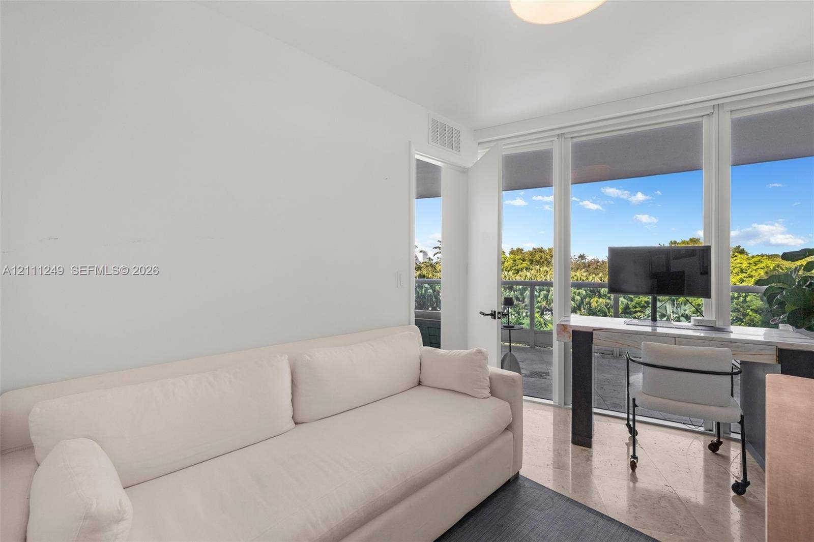 Full-height glass sliding doors, stone flooring, and expansive outdoor terrace with exterior railings
