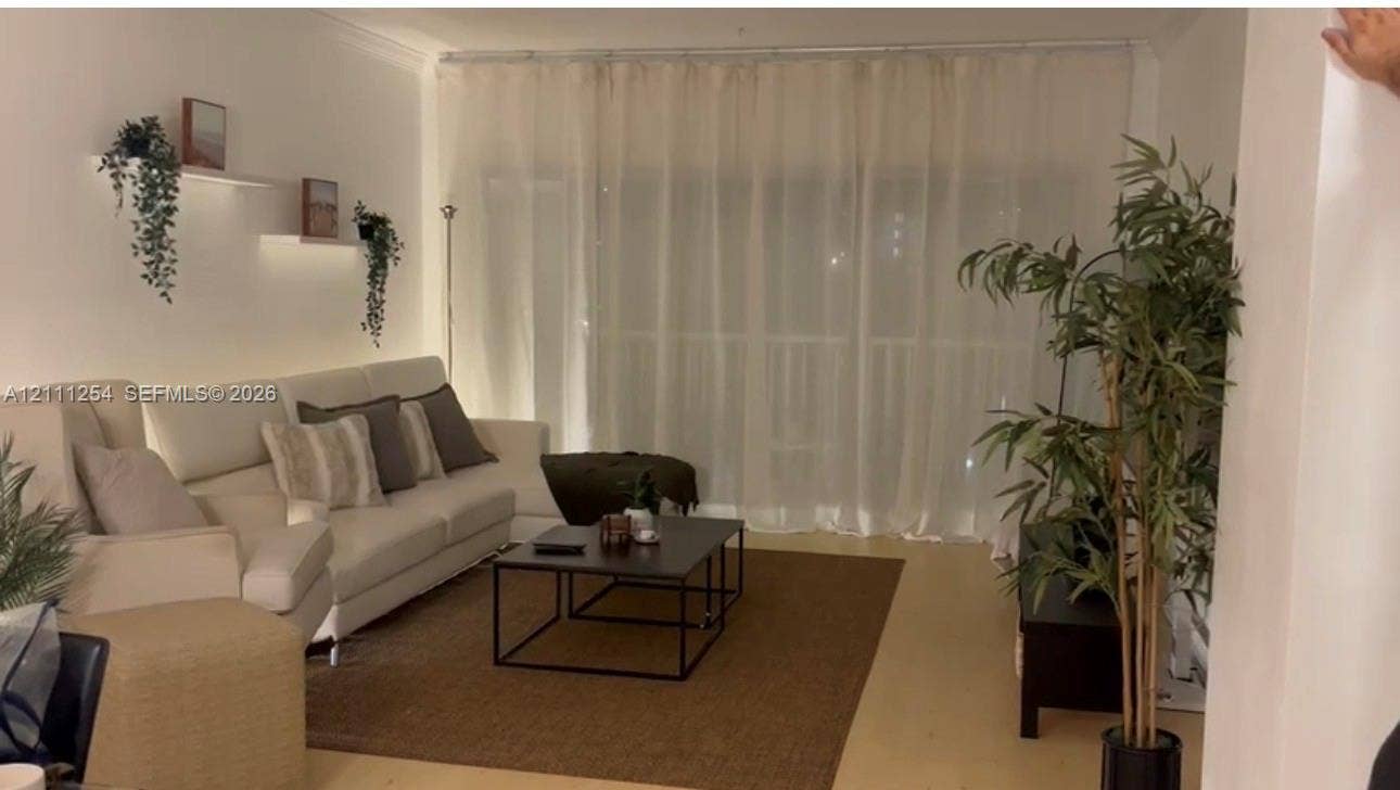 300 Bayview Drive, #409, Sunny Isles Beach, Sunny Isles Beach, FL 33160 Interior space featuring light-toned flooring, wall-mounted display shelving with integrated lighting, and floor-to-ceiling window treatment