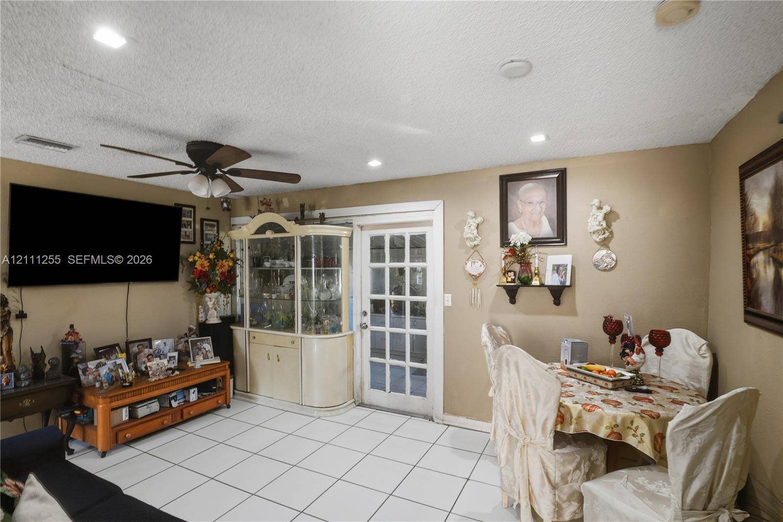 Living space featuring ceramic tile flooring, recessed lighting, ceiling fan, and glass-paned exterior door